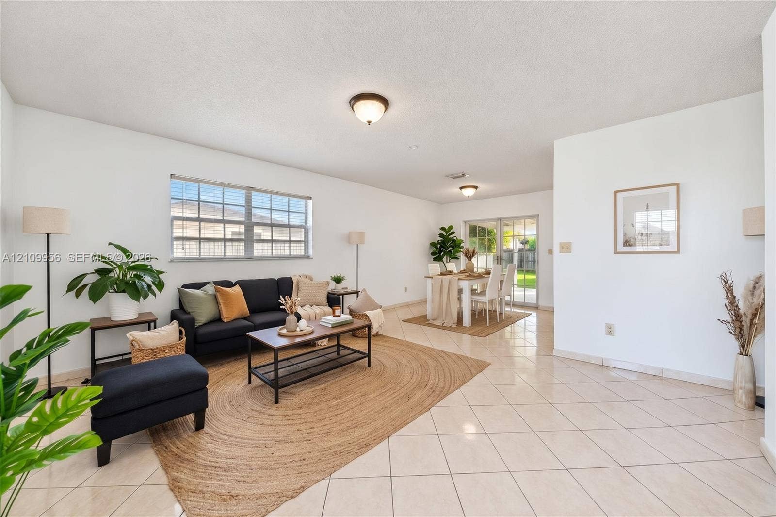 19503 SW 114th Place, Miami, FL 33157 Open-concept interior featuring light-colored tile flooring, flush-mount ceiling lighting, large windows, and sliding glass doors