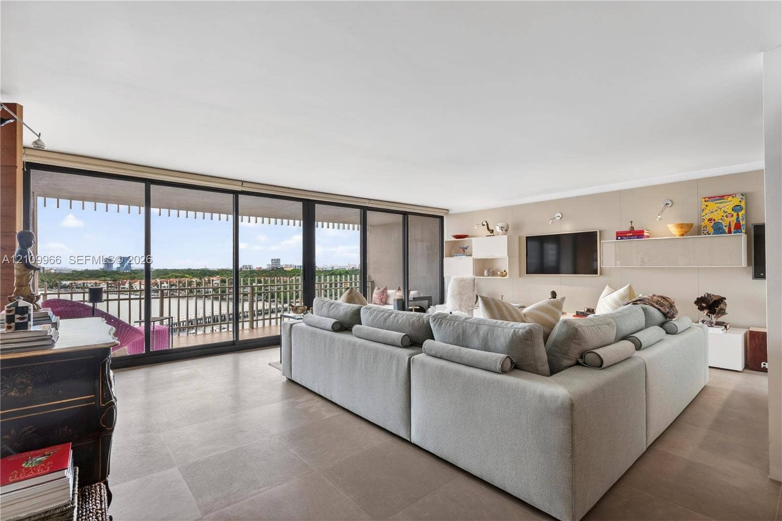 Floor-to-ceiling sliding glass doors, expansive balcony, large-format tile flooring, and built-in wall cabinetry