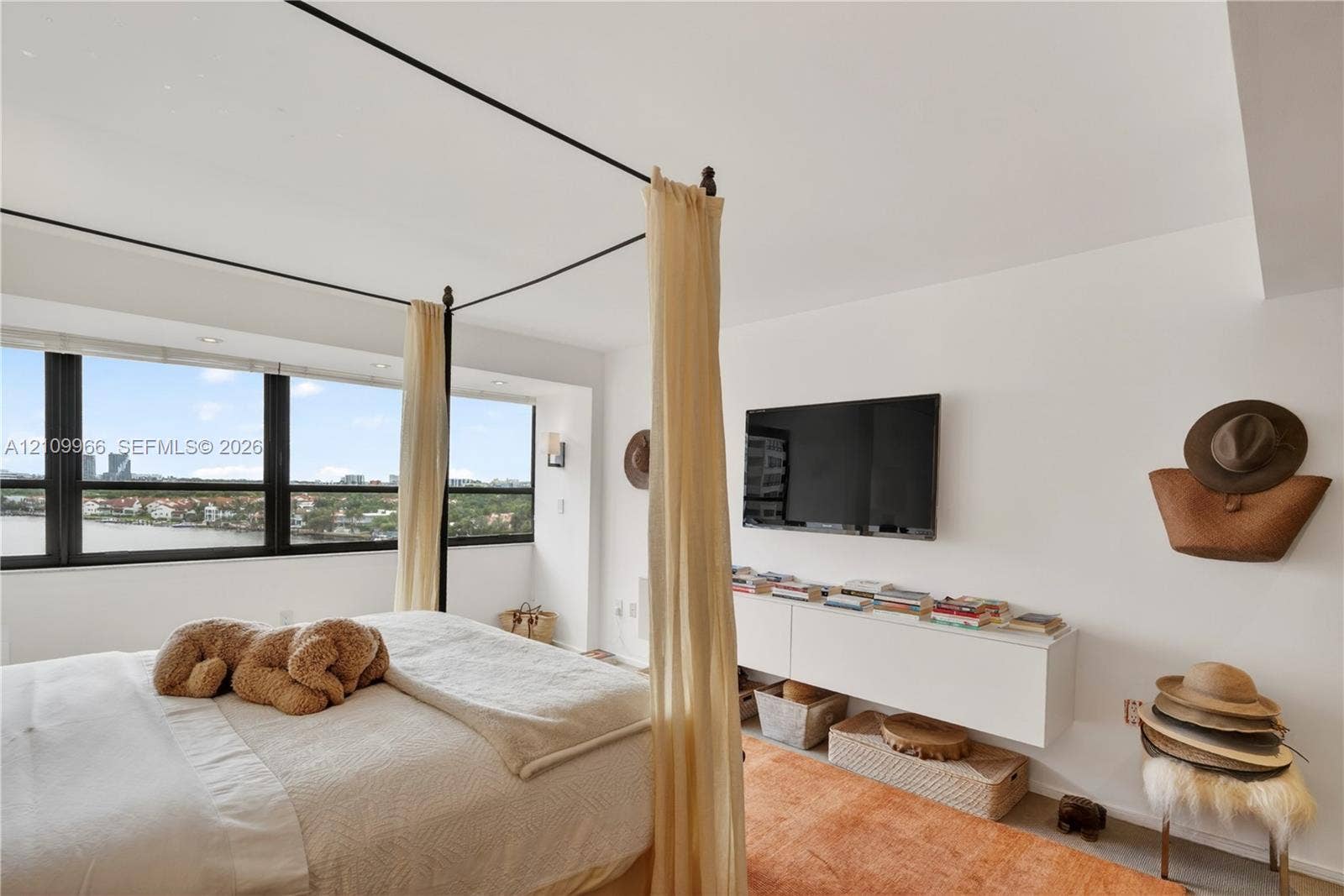Floor-to-ceiling windows with expansive water scenery, wall-mounted white cabinetry, and recessed lighting
