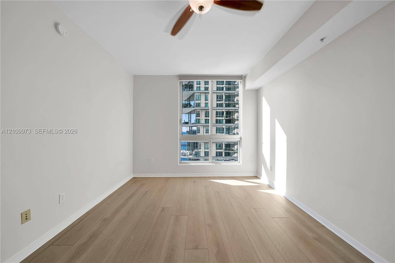 300 S Biscayne Boulevard, #T-1806, Miami, Miami, FL 33131 Interior room featuring wood-finish flooring, a large window with exterior glass building exposure, and a ceiling-mounted fan with light fixture