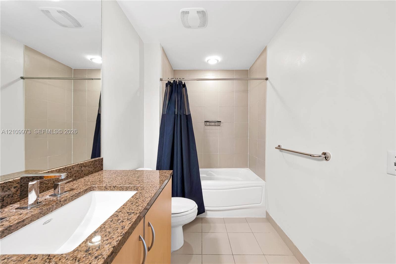 300 S Biscayne Boulevard, #T-1806, Miami, Miami, FL 33131 Bathroom featuring a stone-look countertop, integrated sink, vanity cabinetry, and a tub-shower combination with tile surround