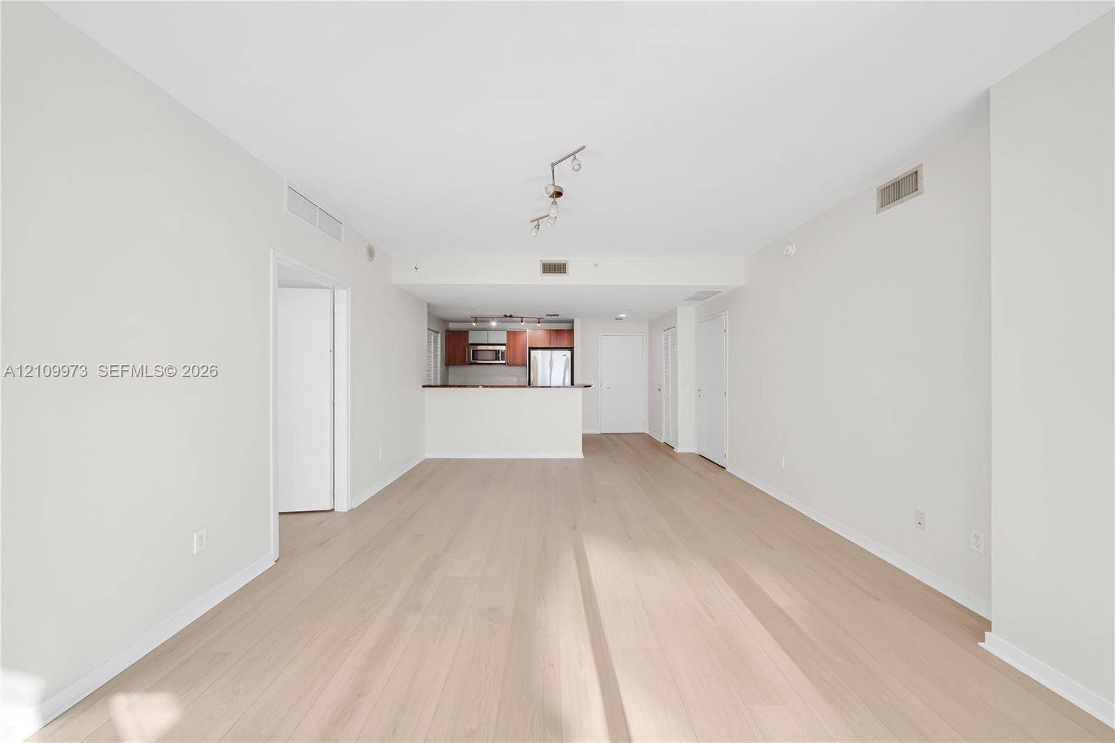 300 S Biscayne Boulevard, #T-1806, Miami, Miami, FL 33131 Open-concept interior featuring wood-finish flooring, a kitchen breakfast bar, and track lighting