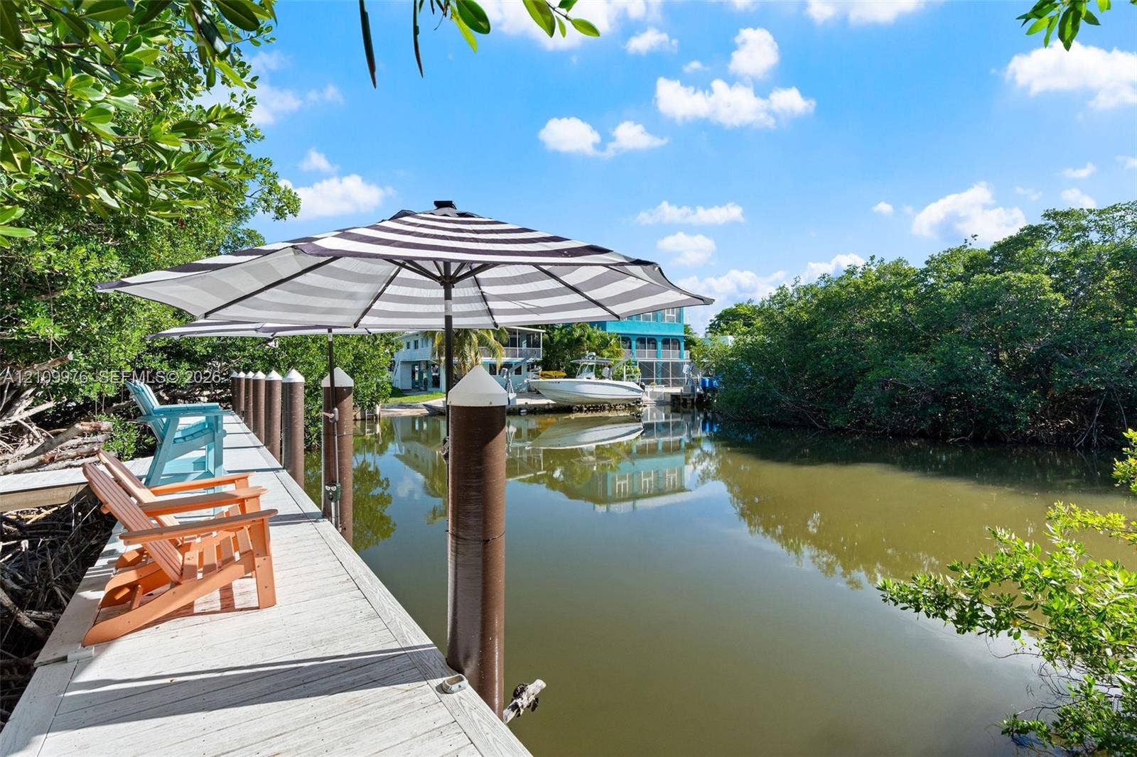43 Waterways Drive, Key Largo, FL 33037 Private dock featuring wood-plank decking and vertical mooring pilings situated on a canal with mangrove foliage