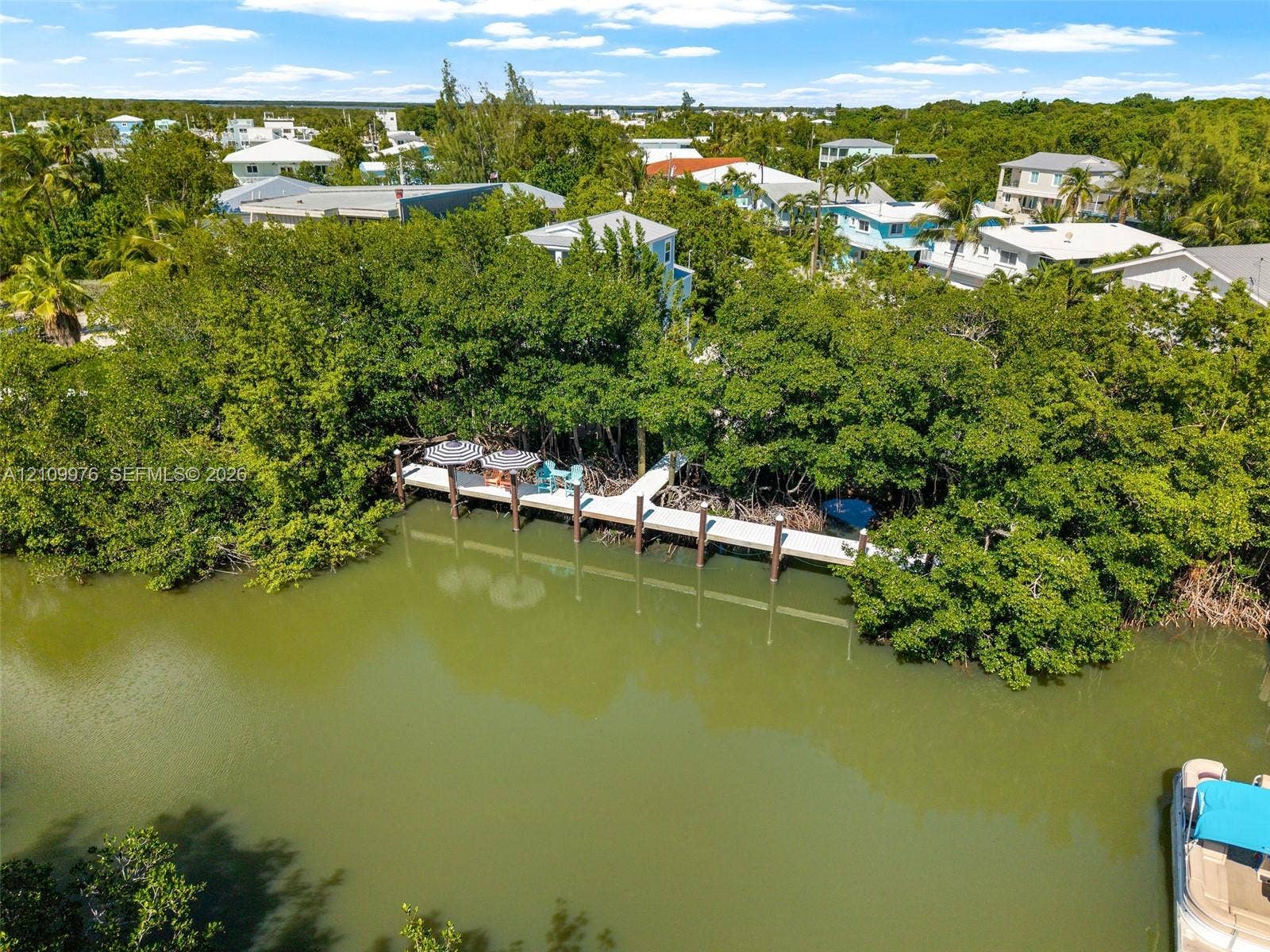 43 Waterways Drive, Key Largo, FL 33037 Waterfront property featuring a private dock and dense mature vegetation