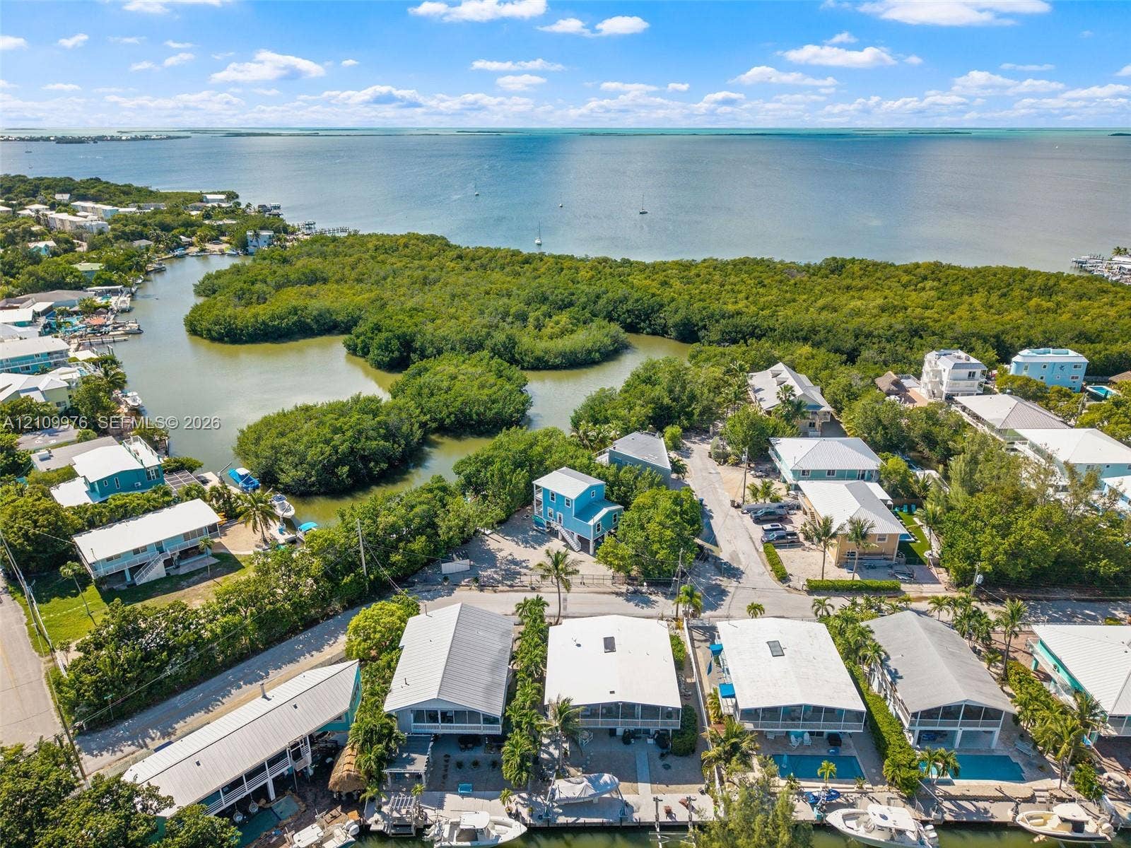 43 Waterways Drive, Key Largo, FL 33037 Aerial perspective of a coastal residential property featuring direct water frontage, private boat docking, and a natural mangrove shoreline