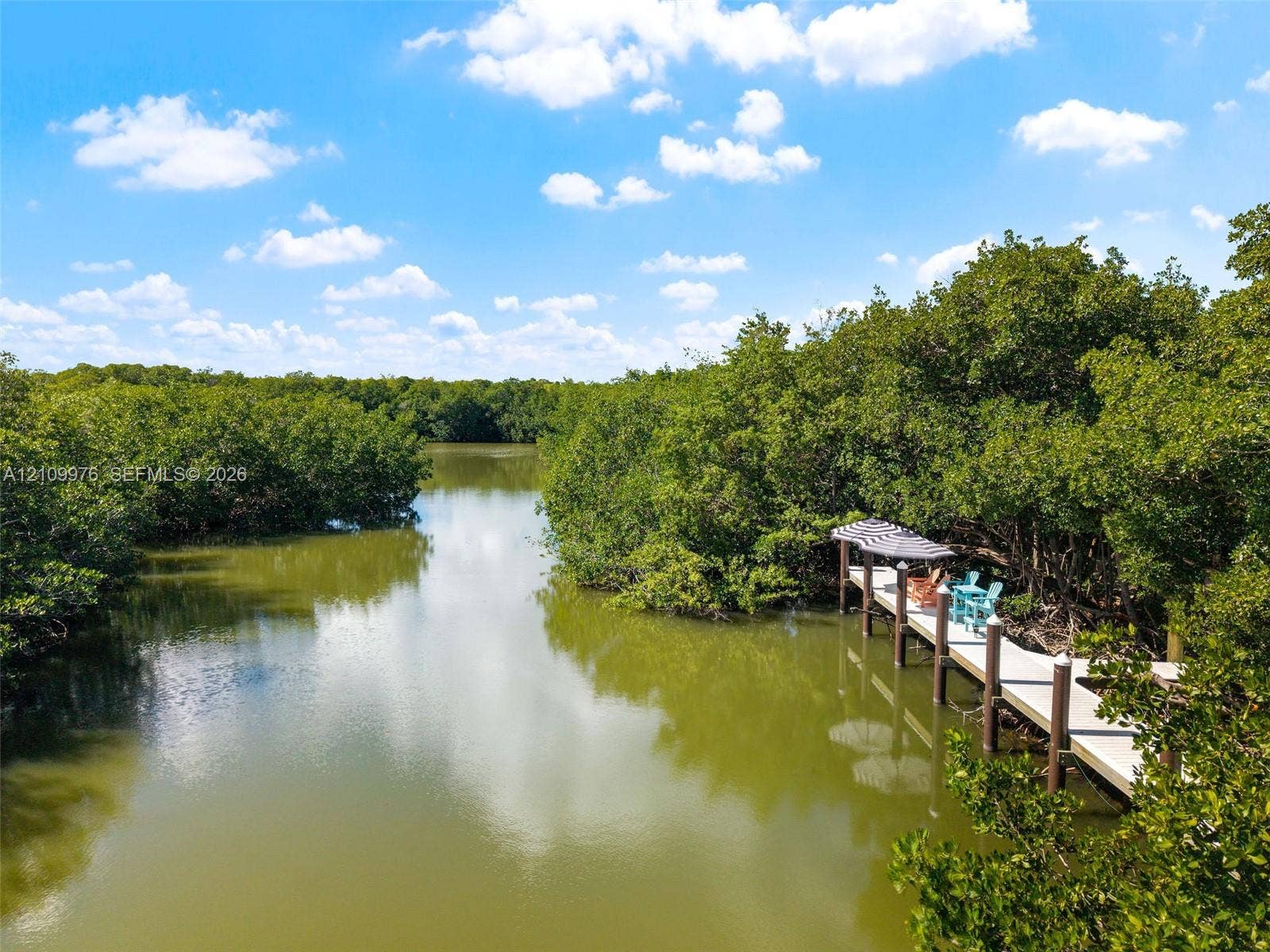 43 Waterways Drive, Key Largo, FL 33037 Private waterfront dock featuring wooden decking, sturdy pilings, and a covered pergola