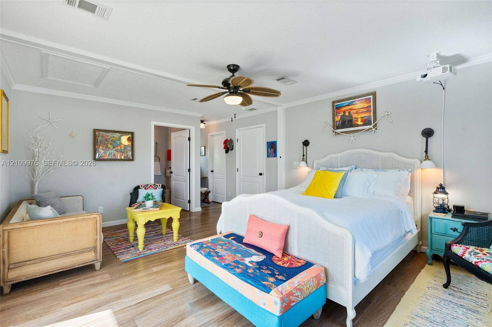43 Waterways Drive, Key Largo, FL 33037 Neutral-toned room featuring wood-finish flooring, crown molding, a central ceiling fan with integrated lighting, and two wall-mounted light fixtures