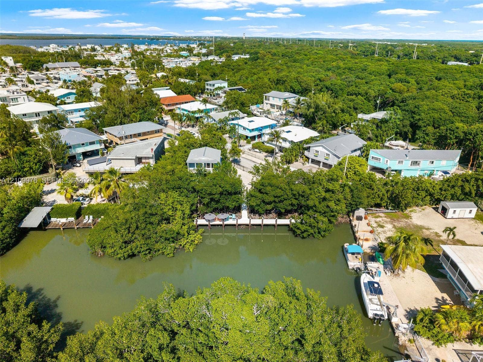 43 Waterways Drive, Key Largo, FL 33037 Aerial perspective of canal-front property featuring a private boat dock, natural vegetation, and direct water access
