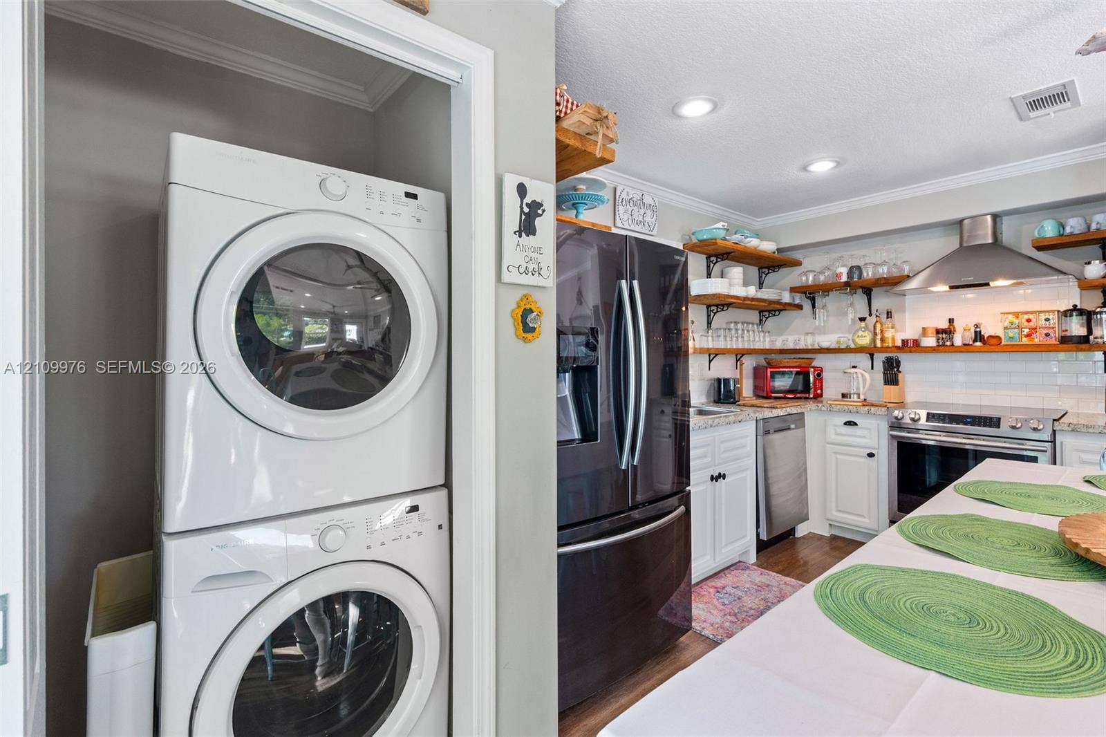 43 Waterways Drive, Key Largo, FL 33037 Stacked laundry unit, white cabinetry with stone countertops, stainless steel appliance suite, and open shelving