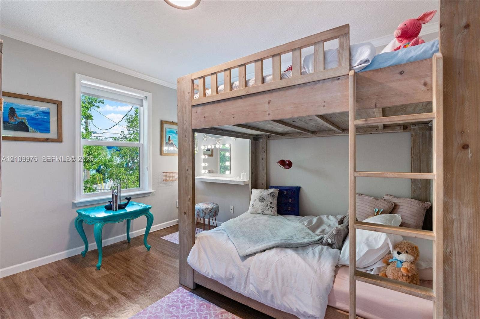 43 Waterways Drive, Key Largo, FL 33037 Bedroom featuring wood-finish flooring, a large window with exterior greenery, and a built-in wall-mounted shelf