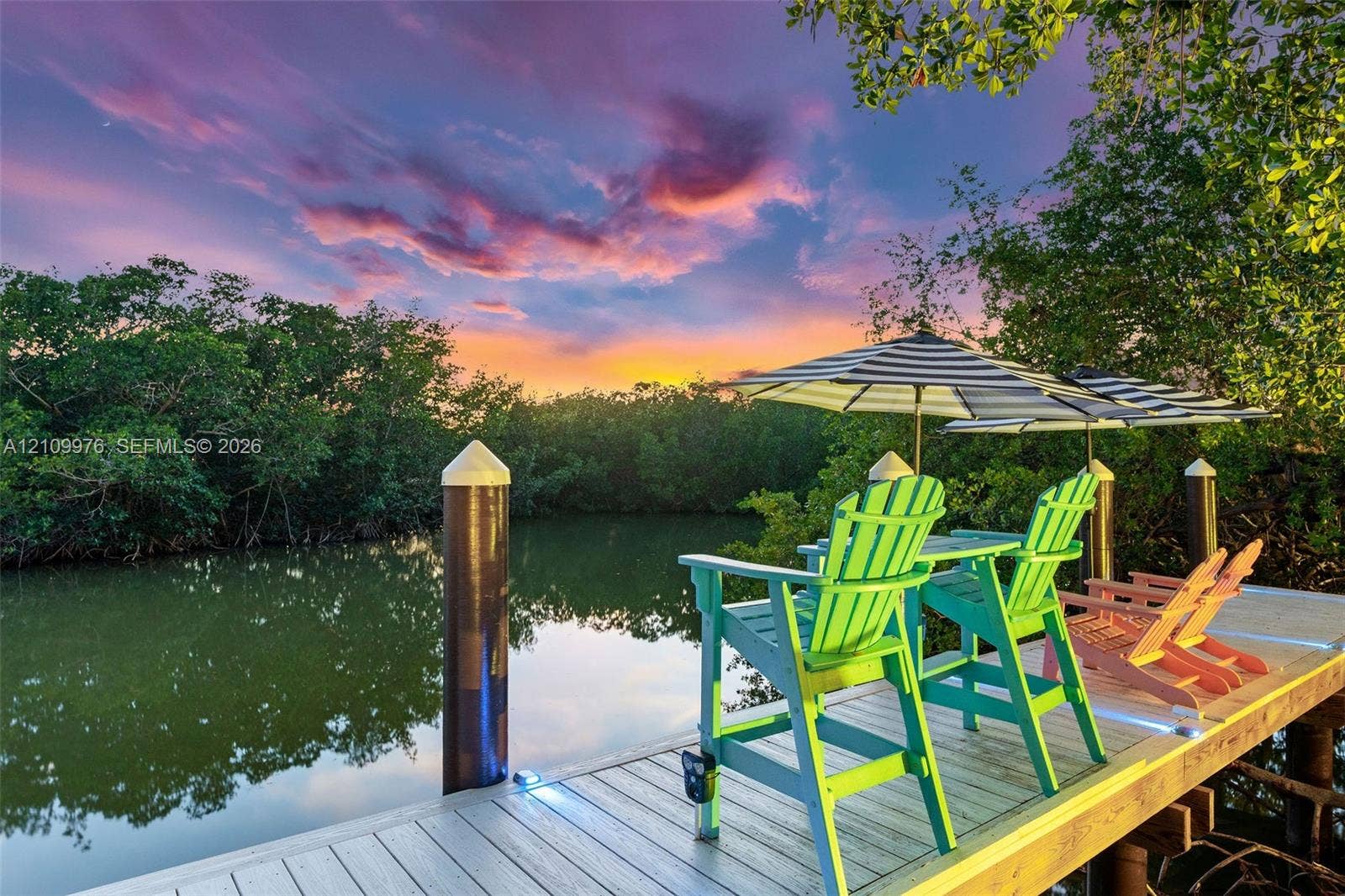 43 Waterways Drive, Key Largo, FL 33037 Private dock featuring composite decking, integrated surface lighting, and cylindrical mooring pilings set against a backdrop of mature mangroves