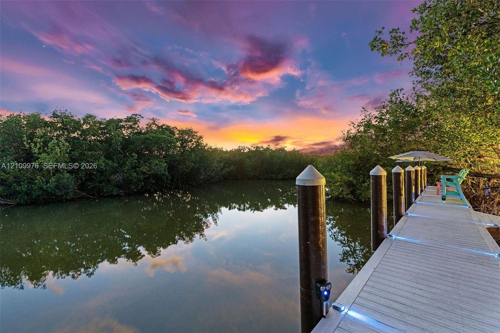 43 Waterways Drive, Key Largo, FL 33037 Waterfront dock featuring composite decking, integrated LED lighting, and capped pilings set against a natural mangrove backdrop
