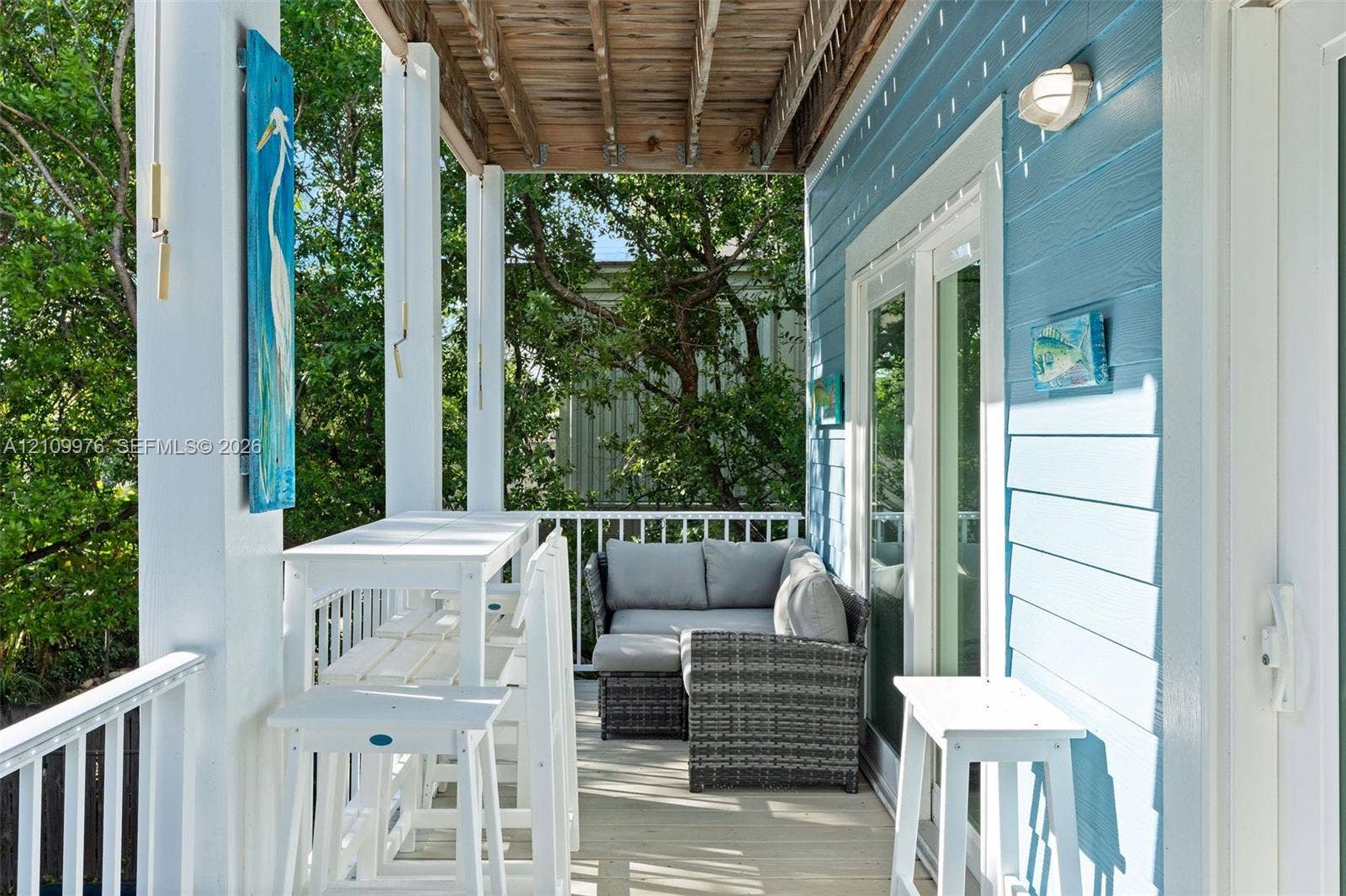 43 Waterways Drive, Key Largo, FL 33037 Covered porch featuring lap siding, white structural columns, wood-plank flooring, and double glass doors