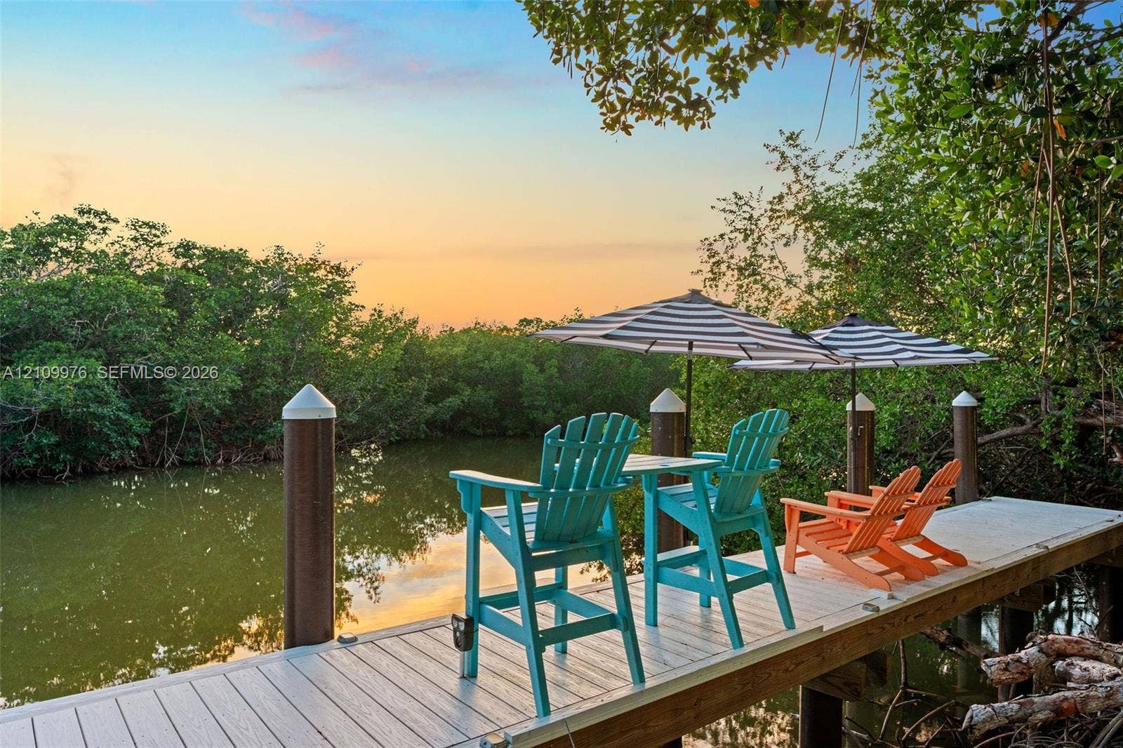 43 Waterways Drive, Key Largo, FL 33037 Waterfront dock featuring composite decking and anchored pilings surrounded by dense mature vegetation
