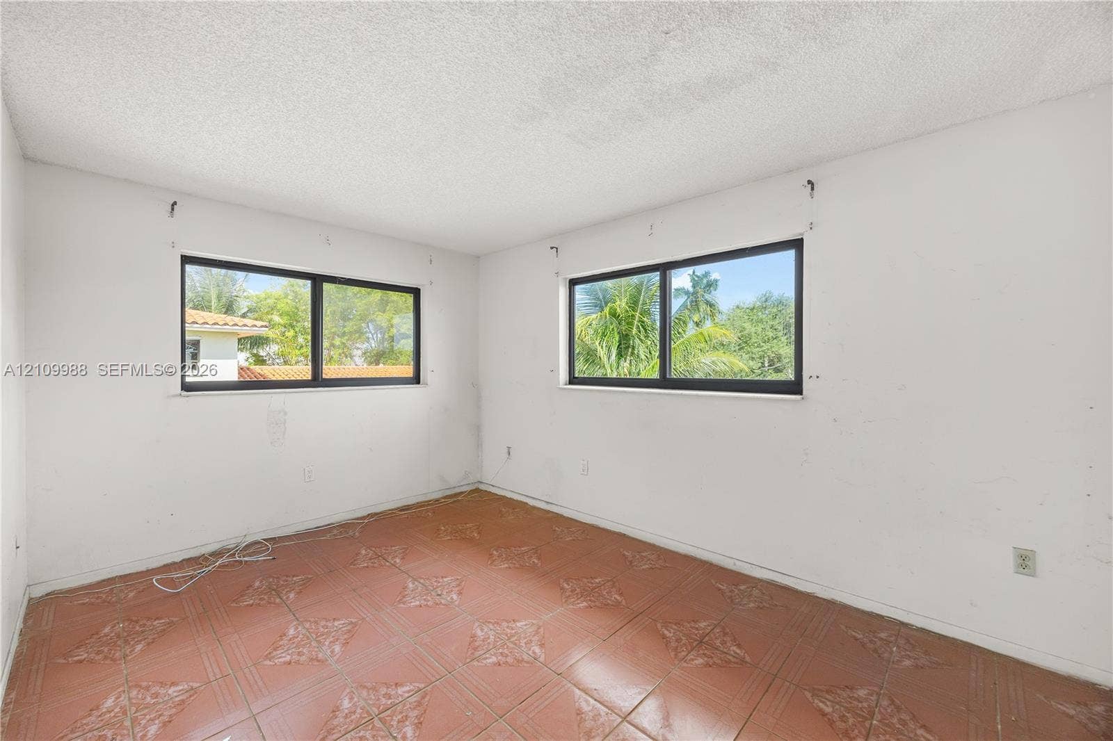 13946 NE 4th Avenue, #13946, Miami, FL 33161 Interior room featuring tile flooring with decorative detailing and two horizontal sliding windows with dark frames