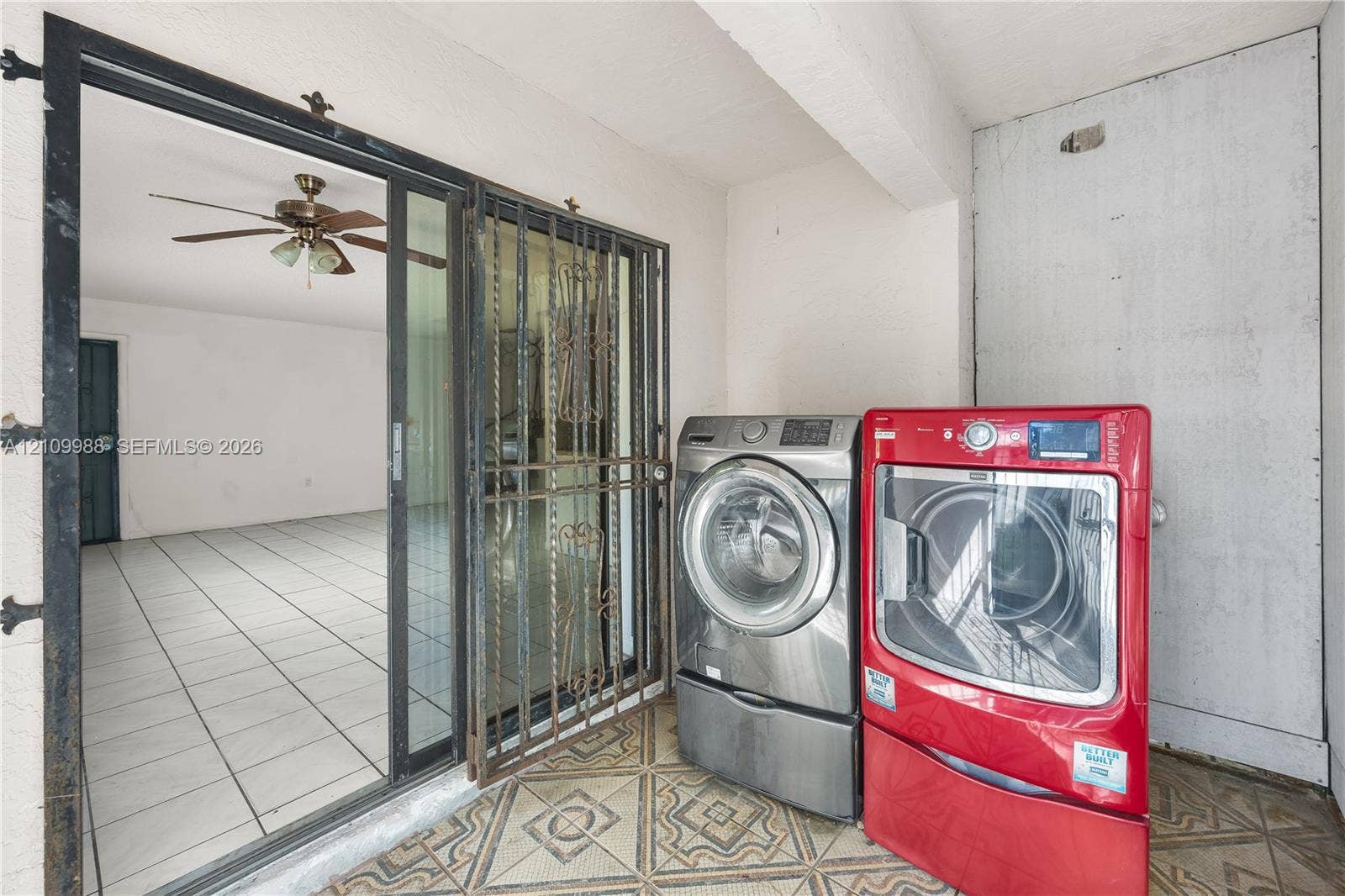 13946 NE 4th Avenue, #13946, Miami, FL 33161 Covered patio featuring patterned tile flooring, a metal security screen door, and a sliding glass door