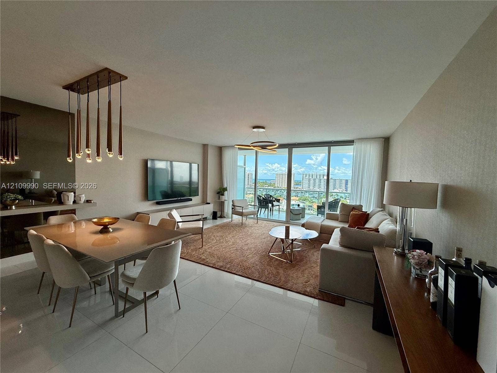 Large-format polished tile flooring, floor-to-ceiling glass sliding doors, modern multi-pendant dining chandelier, and geometric ceiling lighting fixture