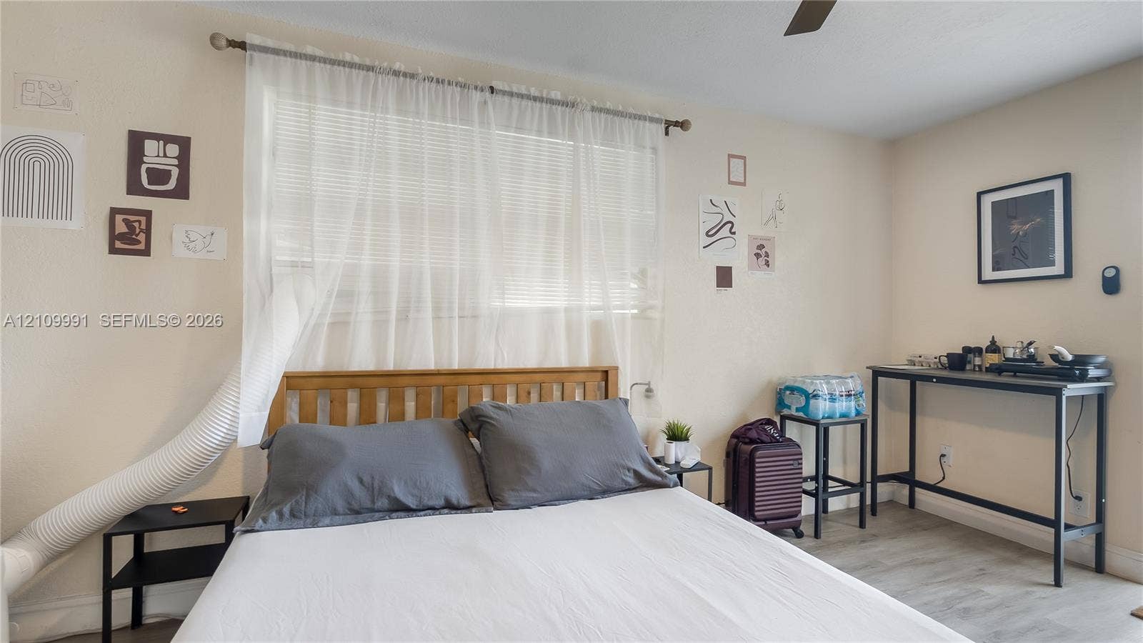 Interior space featuring wood-finish flooring, a horizontal window with adjustable blinds, and a ceiling-mounted fan