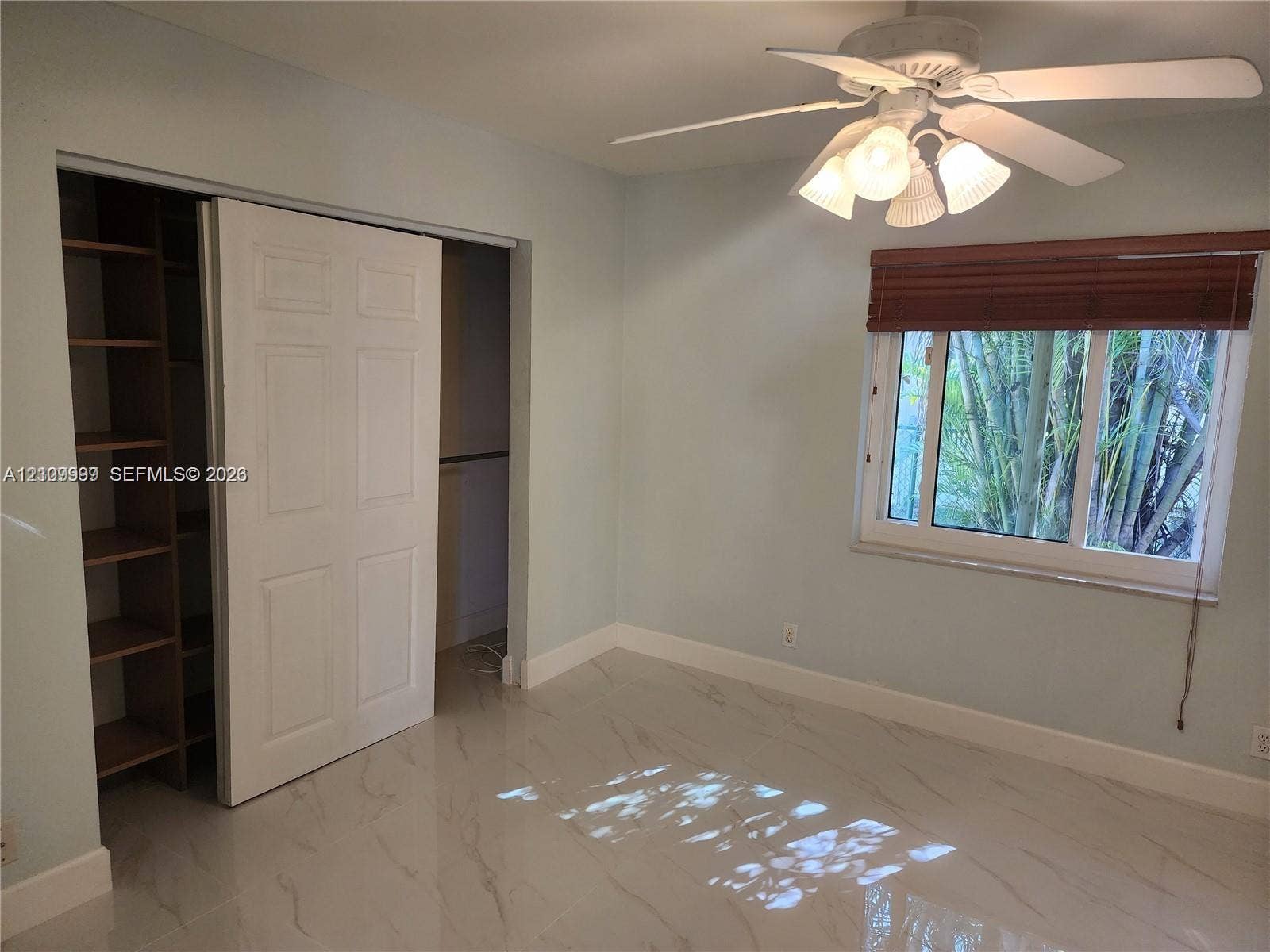1794 NW 112th Terrace, Coral Springs, Coral Springs, FL 33071 Large-format tile flooring, ceiling fan with integrated lighting, window with fitted blinds, and built-in closet shelving