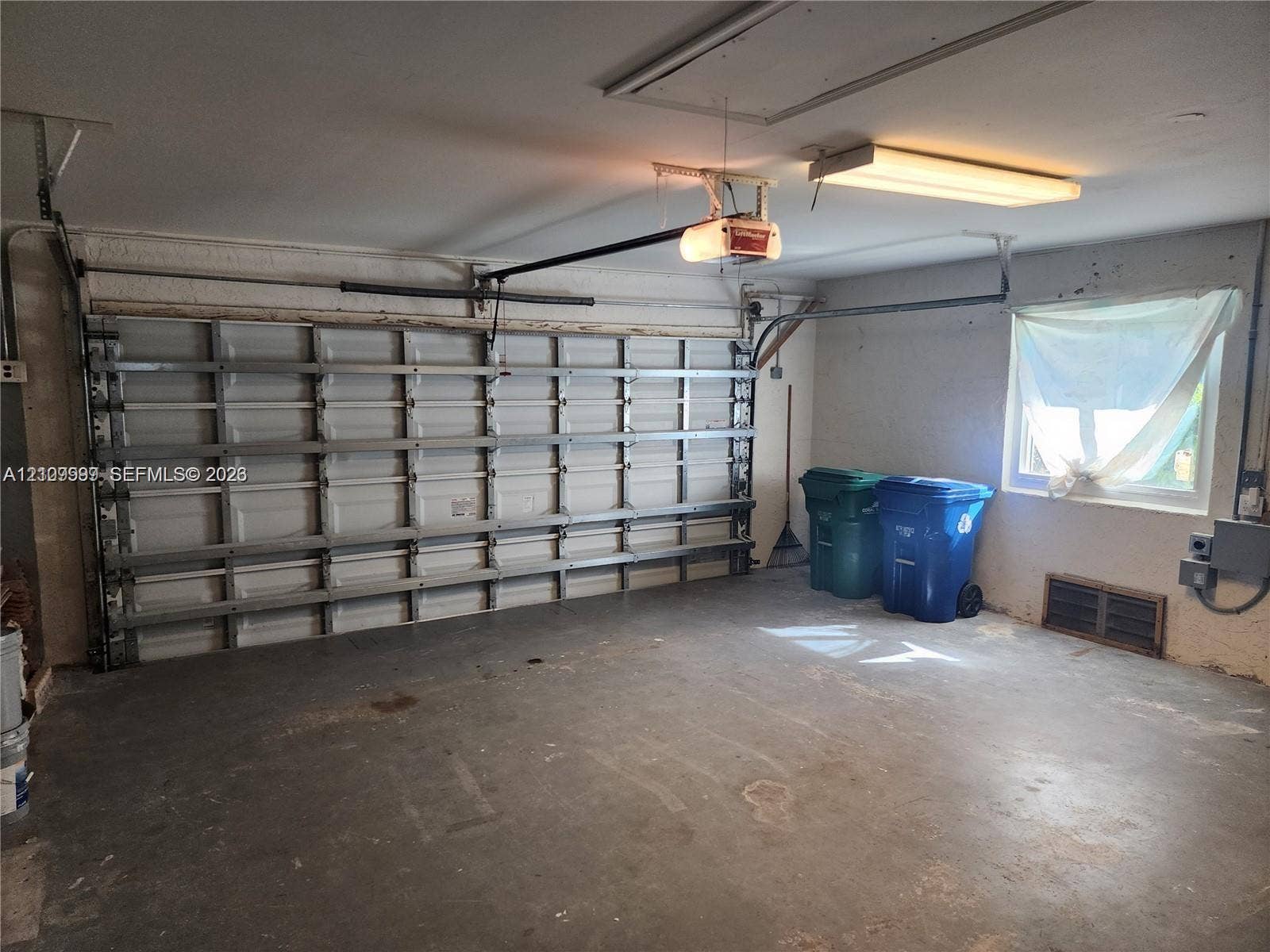 1794 NW 112th Terrace, Coral Springs, Coral Springs, FL 33071 Enclosed garage featuring a multi-panel overhead door, automatic door opener, fluorescent overhead lighting, and an exterior window