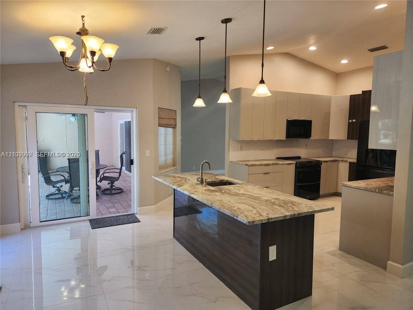 1794 NW 112th Terrace, Coral Springs, Coral Springs, FL 33071 Kitchen featuring stone-topped island with undermount sink, flat-panel cabinetry, porcelain tile flooring, trio of pendant lights, and sliding glass doors