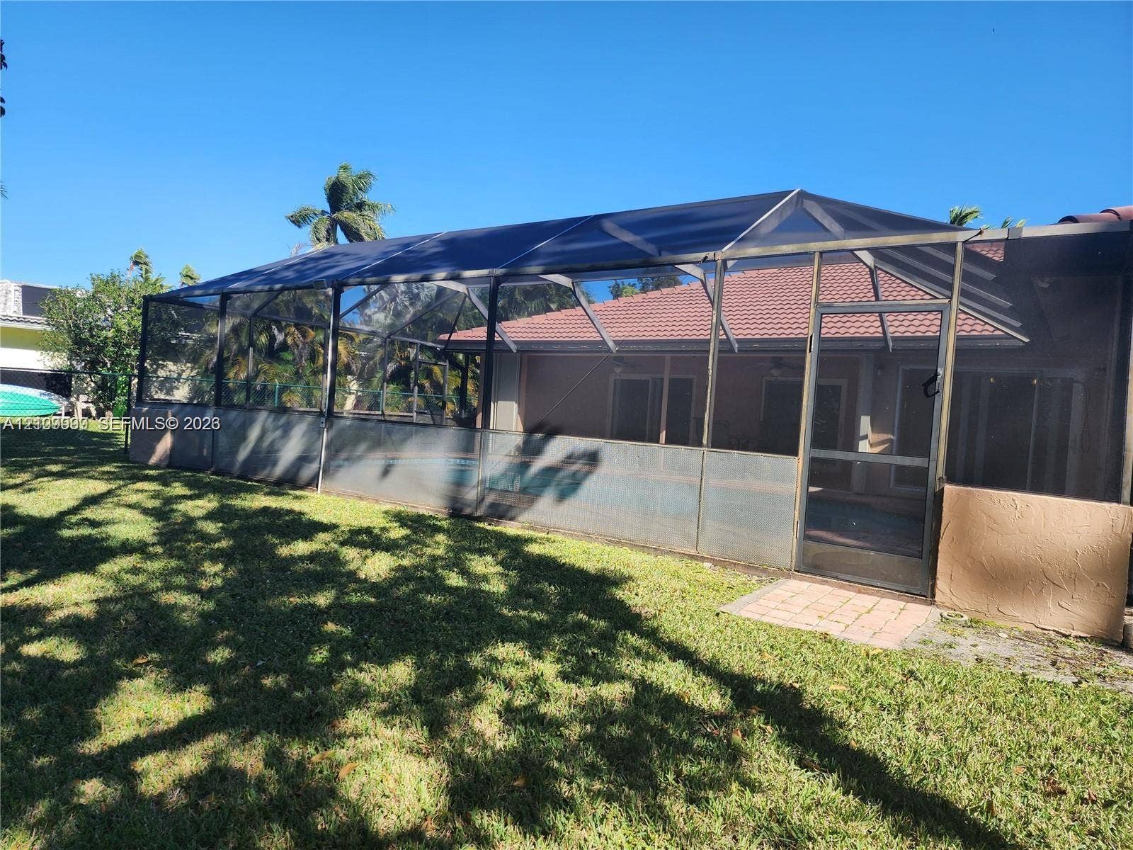 1794 NW 112th Terrace, Coral Springs, Coral Springs, FL 33071 Screened lanai enclosure with a tile roof and brick-paver entry, complemented by an open green space