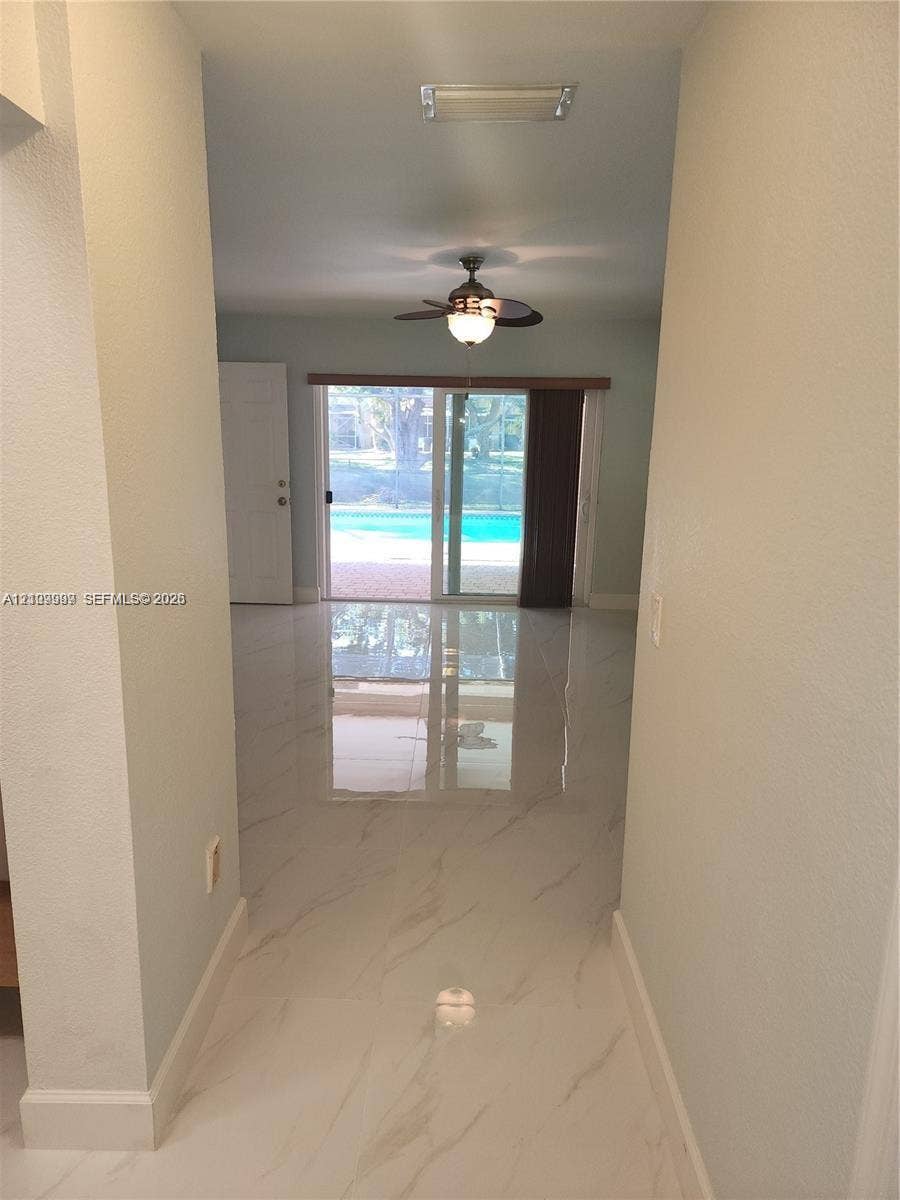 1794 NW 112th Terrace, Coral Springs, Coral Springs, FL 33071 Polished stone-finish tile flooring, ceiling-mounted fan with light fixture, and sliding glass doors providing outdoor access