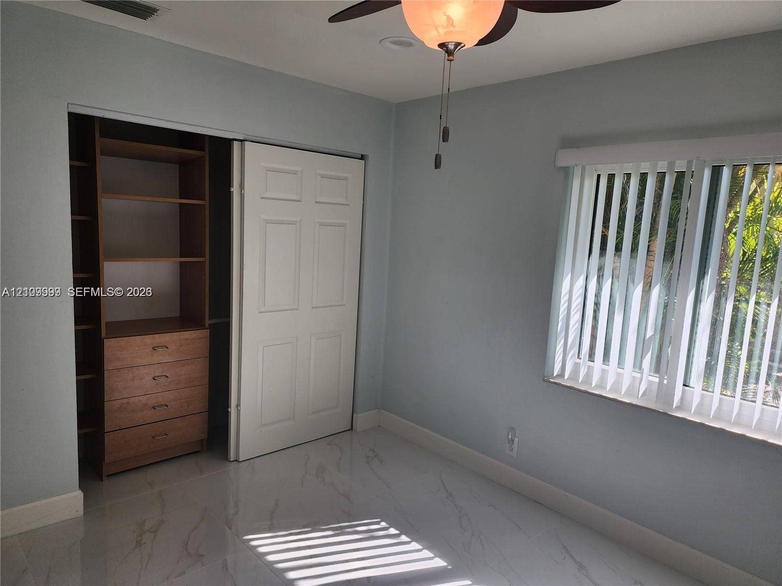 1794 NW 112th Terrace, Coral Springs, Coral Springs, FL 33071 Room featuring large-format tile flooring, a custom-built wood closet system with integrated shelving and drawers, a ceiling fan with integrated lighting, and vertical window blinds