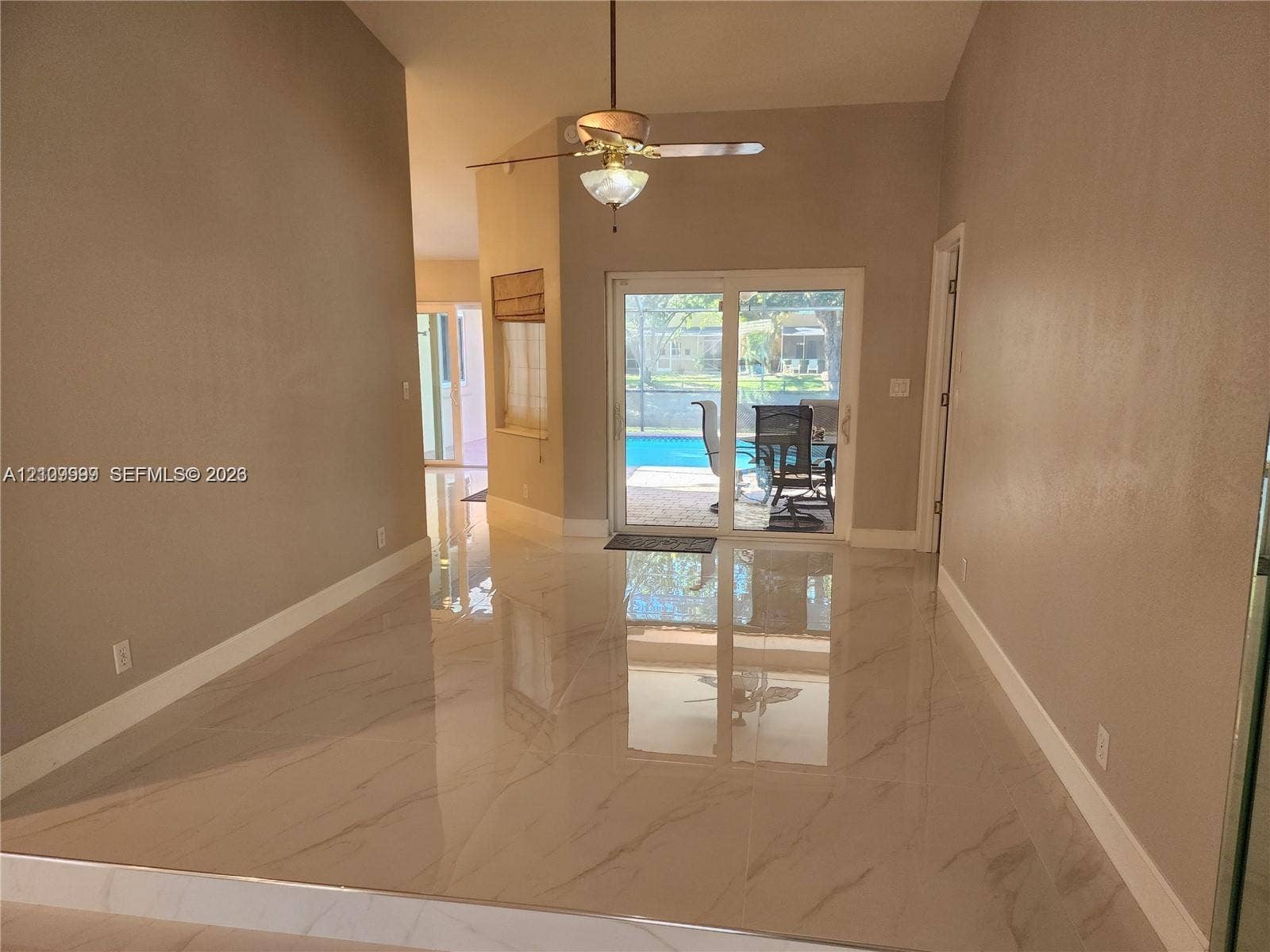 1794 NW 112th Terrace, Coral Springs, Coral Springs, FL 33071 High-ceiling living area featuring large-format polished porcelain tile flooring, sliding glass doors, and a ceiling fan