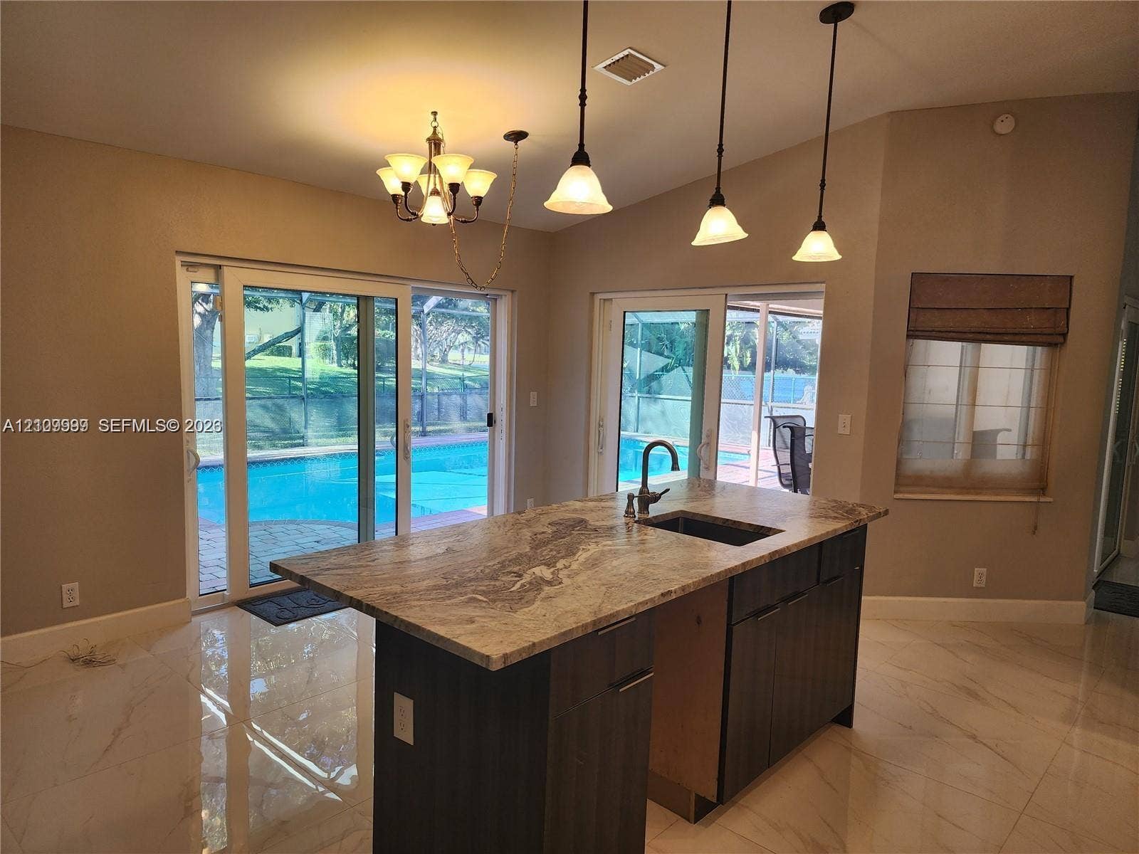 1794 NW 112th Terrace, Coral Springs, Coral Springs, FL 33071 Kitchen featuring an island with a stone countertop, dark wood-finish cabinetry, an undermount sink, a gooseneck faucet, and three pendant light fixtures
