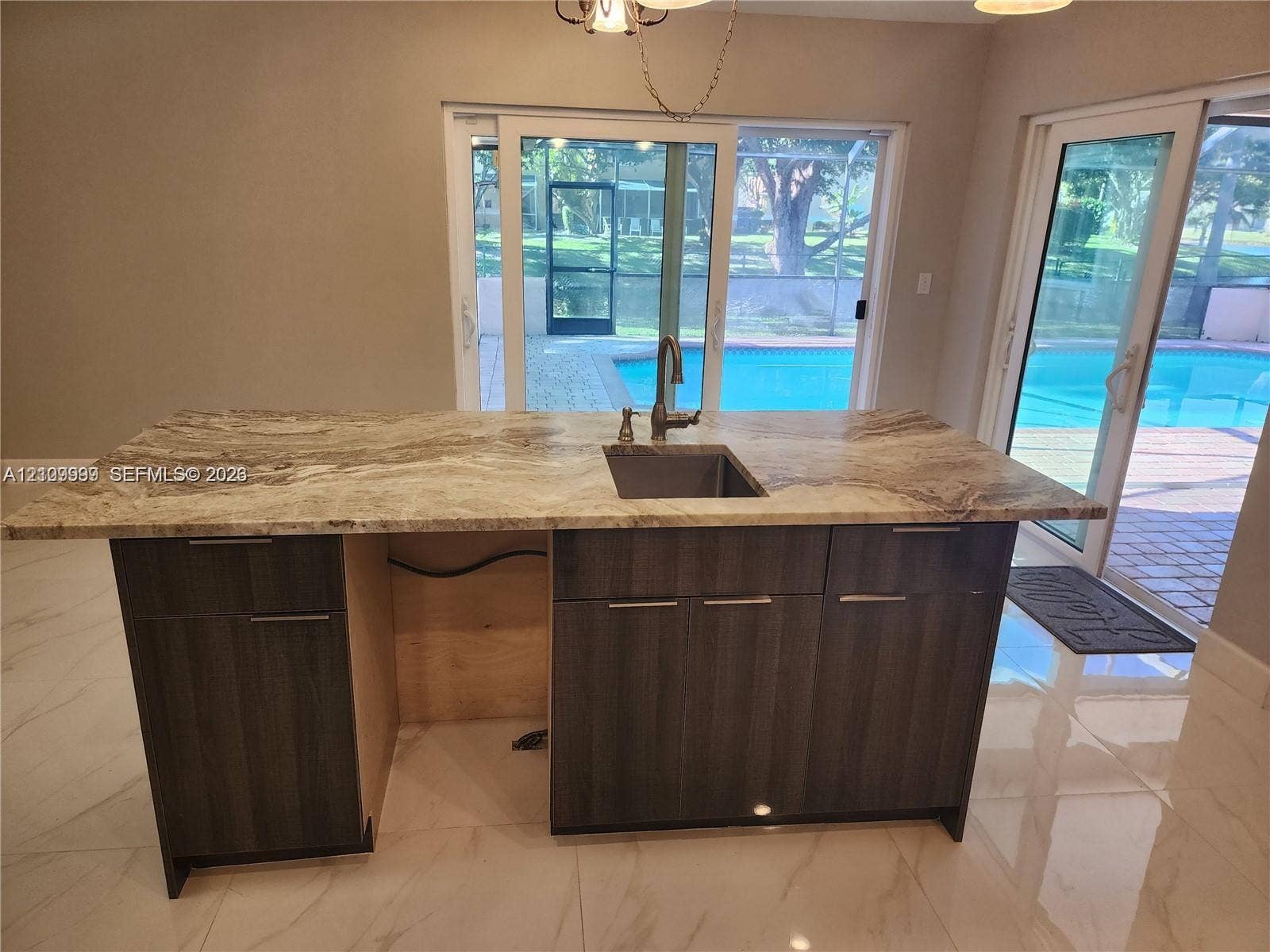 1794 NW 112th Terrace, Coral Springs, Coral Springs, FL 33071 Kitchen island with stone-surface countertop, under-mount sink, high-arc faucet, and dark-finish cabinetry
