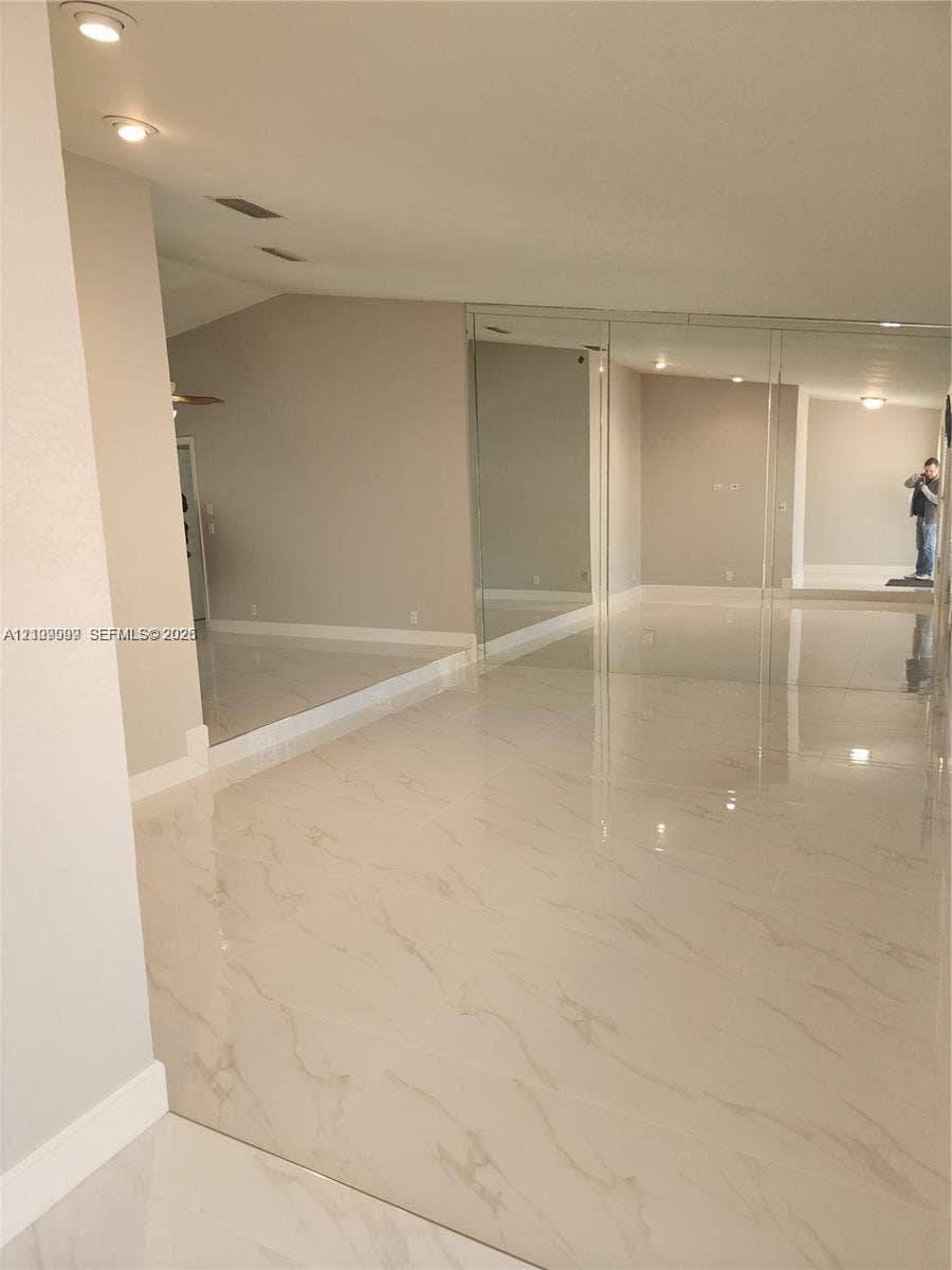 1794 NW 112th Terrace, Coral Springs, Coral Springs, FL 33071 Polished stone-look tile flooring, vaulted ceilings, recessed lighting, and floor-to-ceiling mirrored closet doors