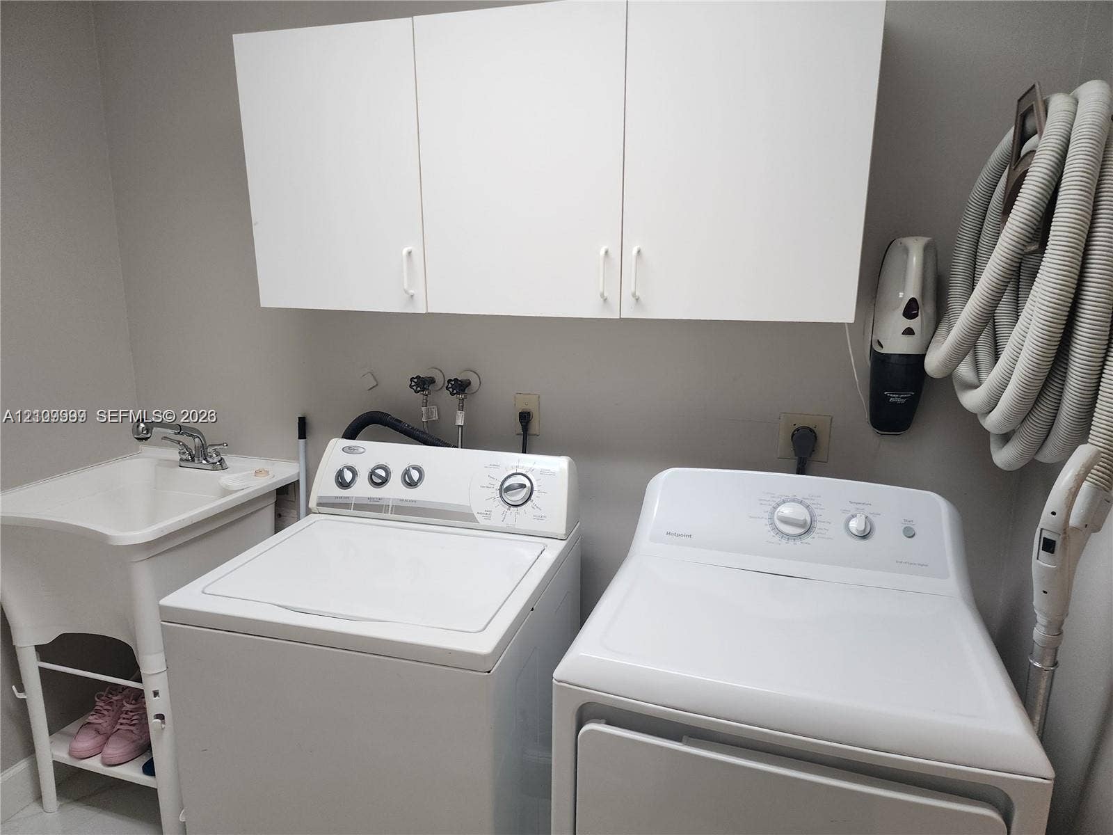 1794 NW 112th Terrace, Coral Springs, Coral Springs, FL 33071 Utility room featuring white cabinetry, a freestanding basin with a chrome faucet, and integrated laundry hookups