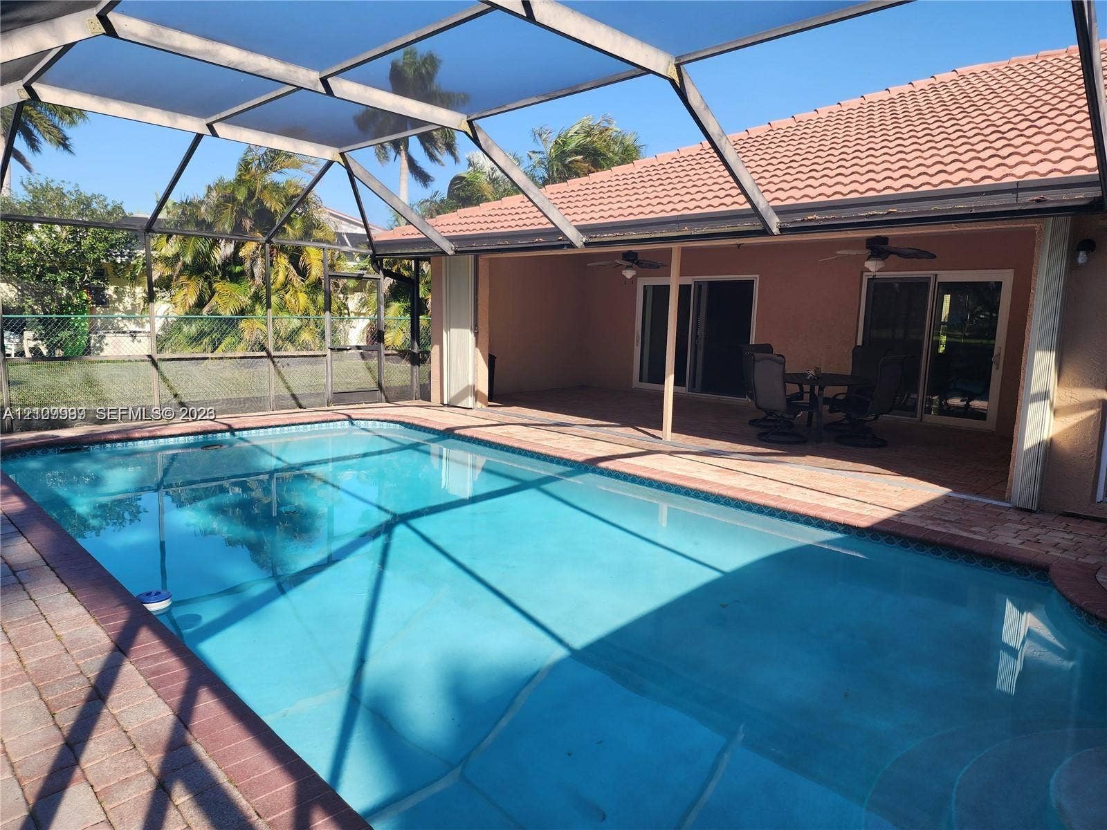 1794 NW 112th Terrace, Coral Springs, Coral Springs, FL 33071 Screen-enclosed swimming pool with a concrete pool deck, covered patio, and tiled roof