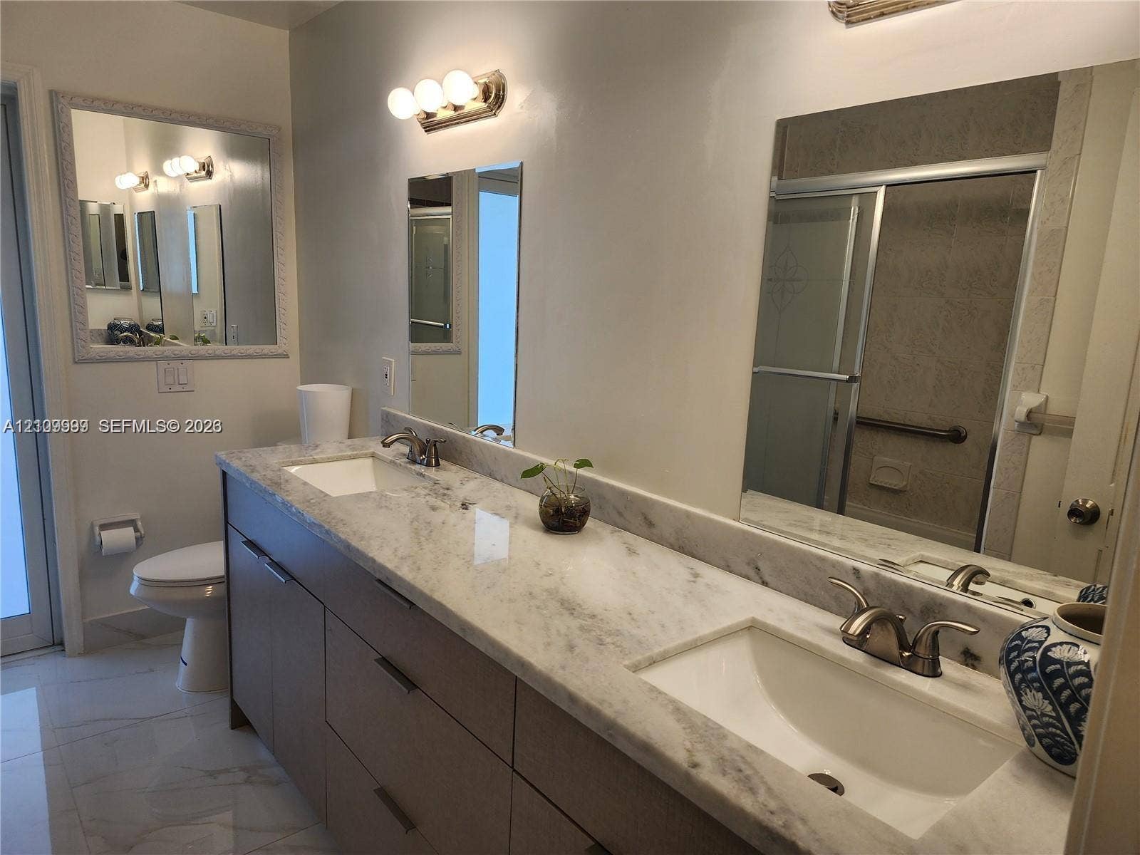 1794 NW 112th Terrace, Coral Springs, Coral Springs, FL 33071 Dual-sink vanity featuring a stone-finish countertop, undermount sinks, contemporary cabinetry, wall-mounted lighting, and full-width mirrors
