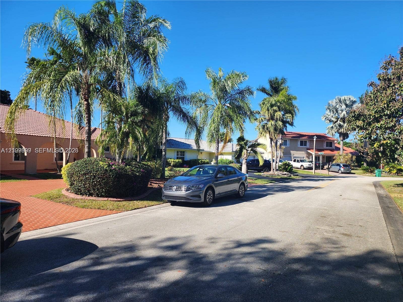 1794 NW 112th Terrace, Coral Springs, Coral Springs, FL 33071 Residential exterior featuring a paved terracotta-toned driveway, stucco siding, a tiled roof, and mature palm landscaping