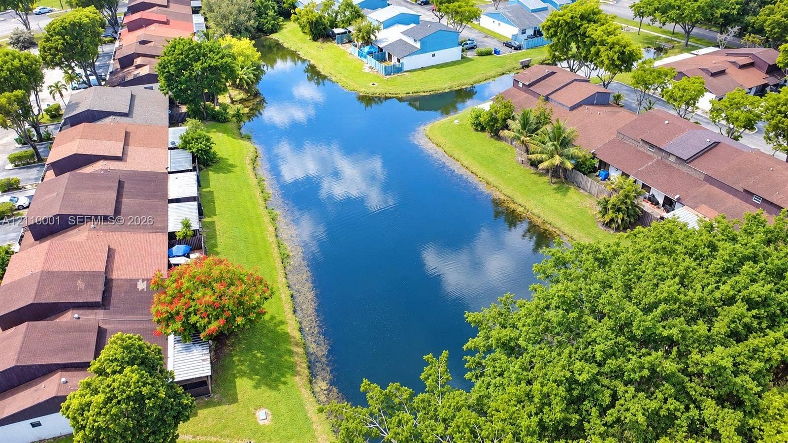 3617 SW 69th Terrace, #24-Z, Miramar, FL 33023 Aerial perspective of a multi-unit residential complex featuring a central canal, mature trees, and manicured green spaces