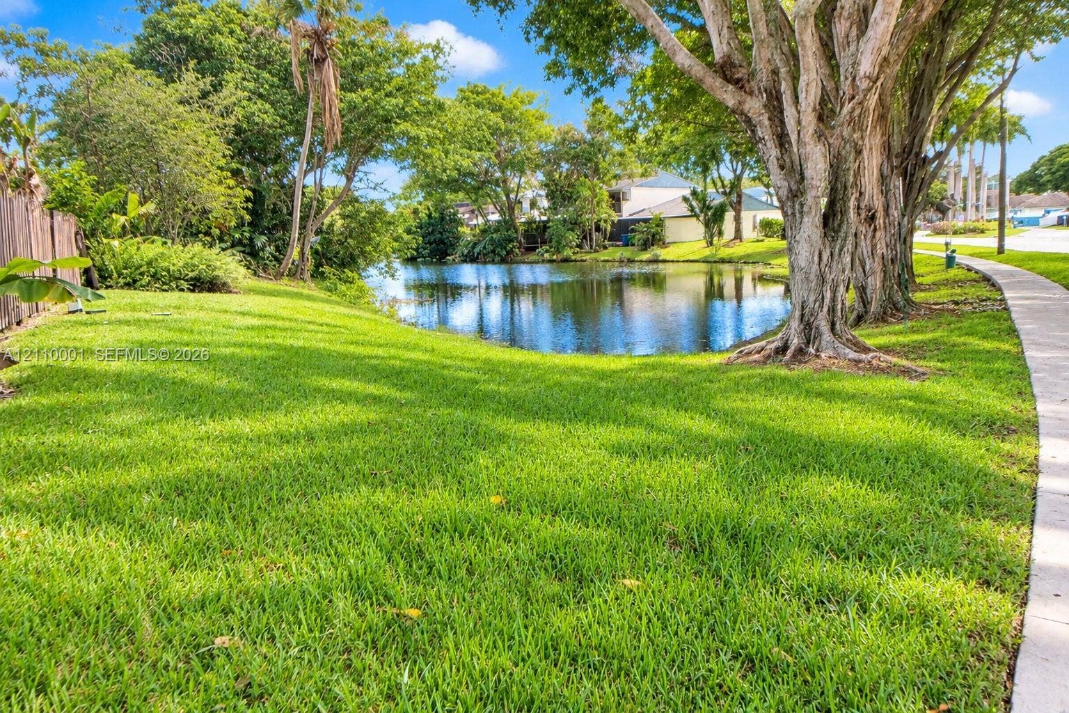 3617 SW 69th Terrace, #24-Z, Miramar, FL 33023 Waterfront lot featuring mature trees, expansive lawn, and concrete perimeter walkway