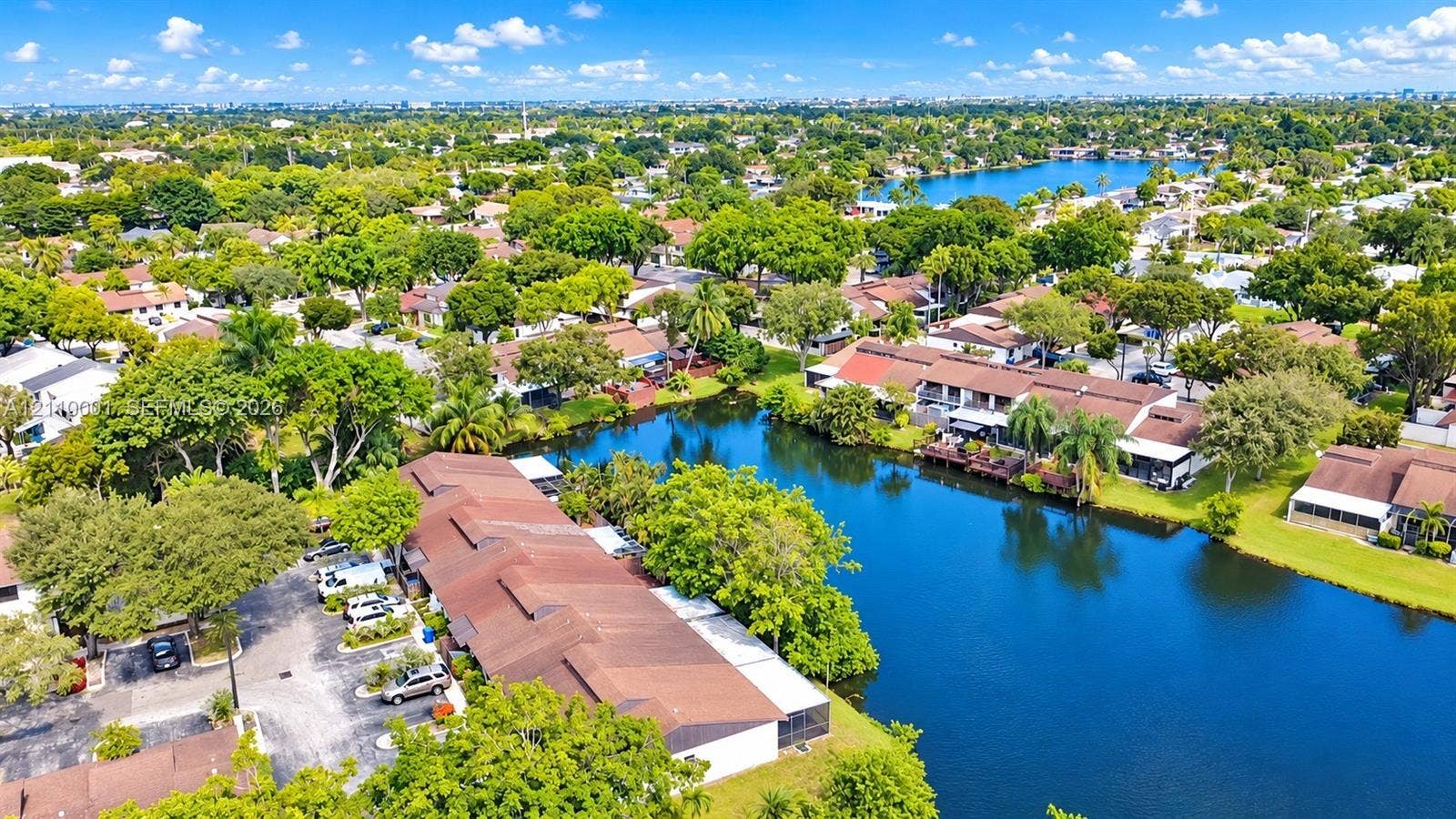 3617 SW 69th Terrace, #24-Z, Miramar, FL 33023 Aerial perspective featuring multi-unit structures with shingle roofing, surface parking, and a prominent water frontage