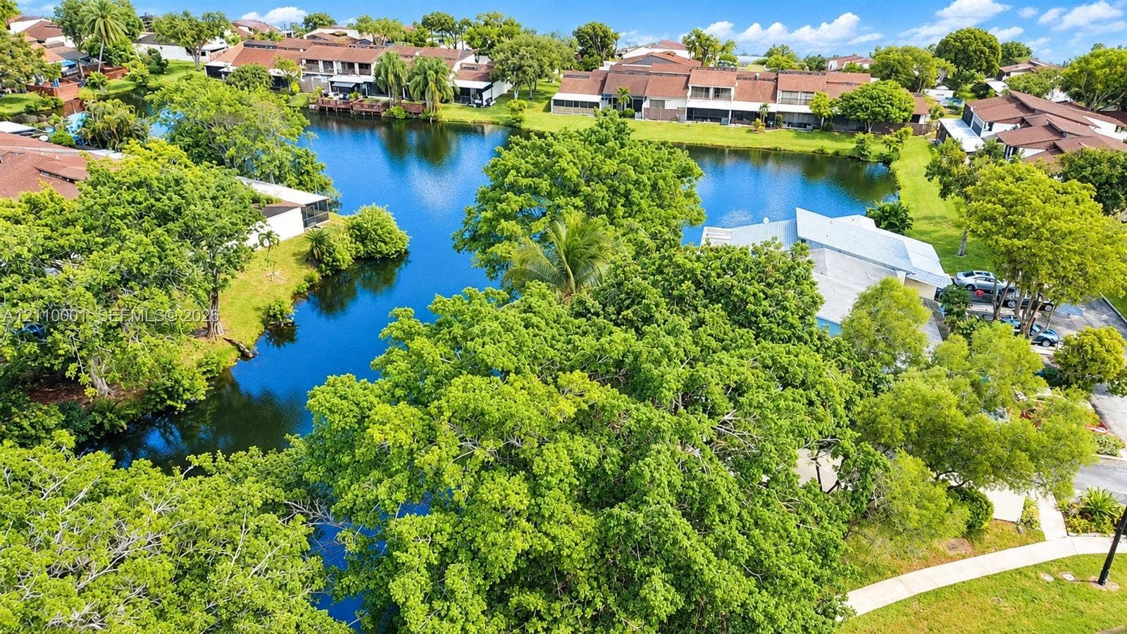 3617 SW 69th Terrace, #24-Z, Miramar, FL 33023 Waterfront property featuring a central lake, mature trees, and landscaped green space
