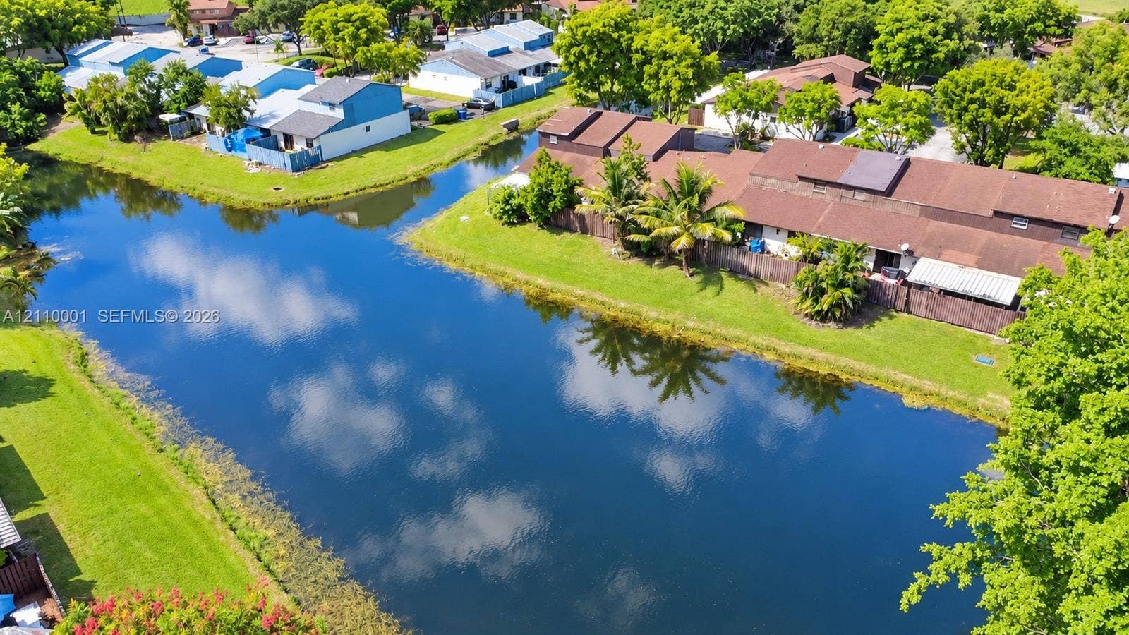 3617 SW 69th Terrace, #24-Z, Miramar, FL 33023 Aerial perspective featuring a waterfront pond, manicured lawn, and mature canopy trees