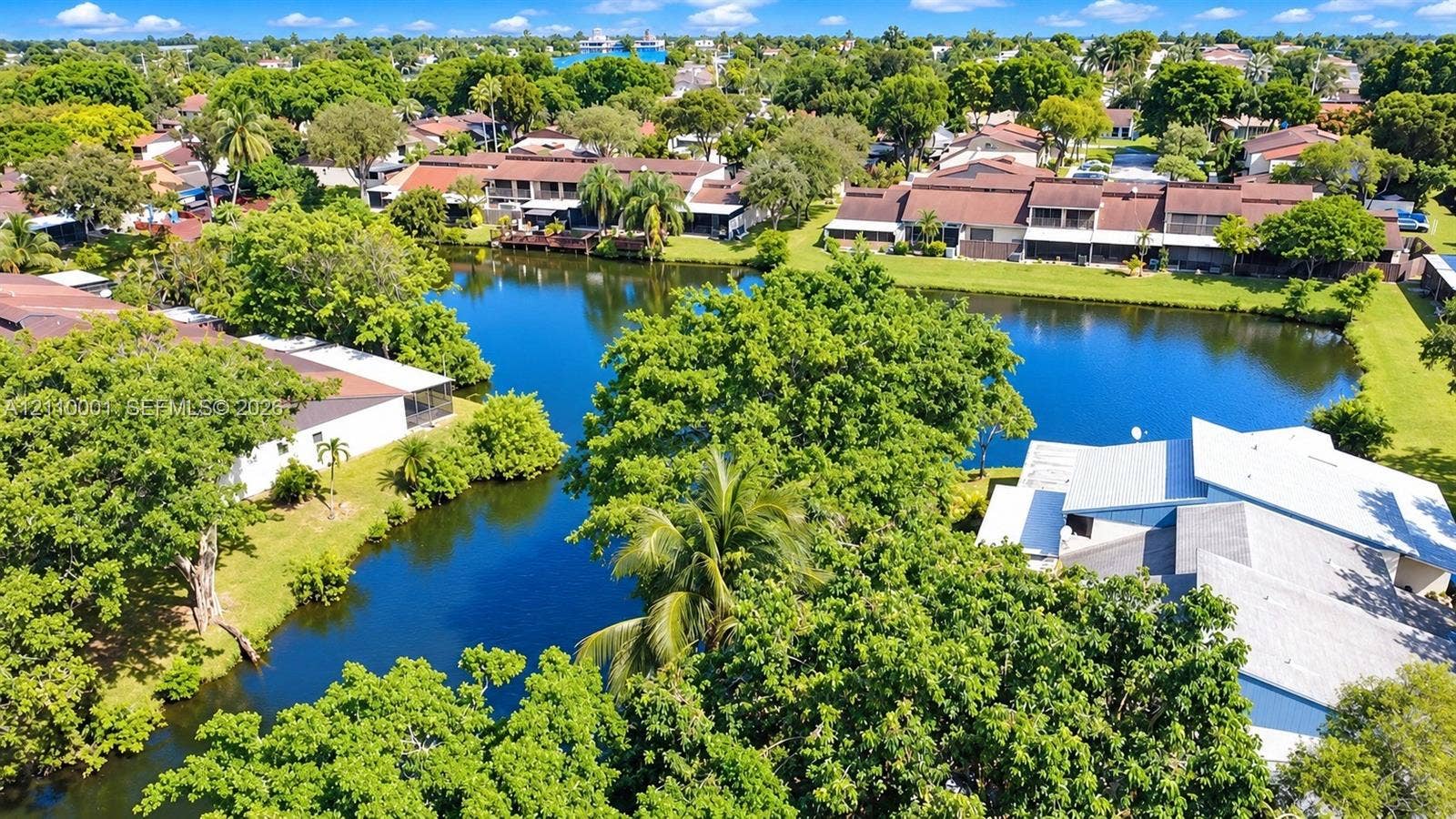 3617 SW 69th Terrace, #24-Z, Miramar, FL 33023 Aerial perspective of waterfront residential grounds featuring mature shade trees, established landscaping, and expansive canal frontage