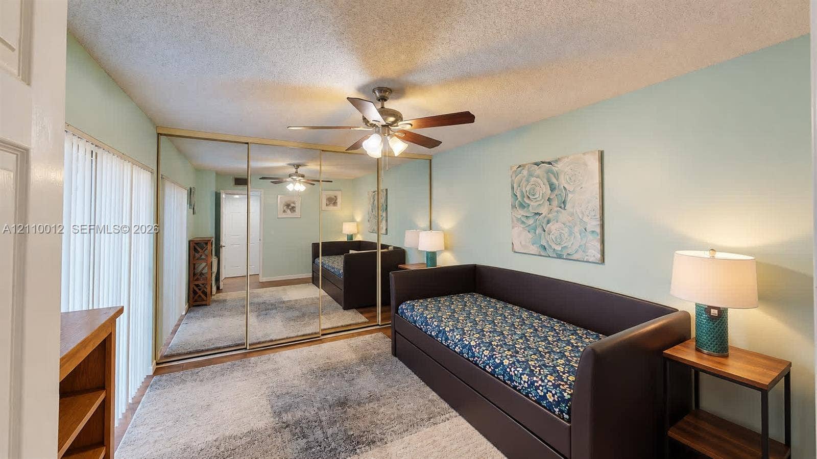 1601 16th Terrace, Palm Beach Gardens, FL 33418 Room featuring mirrored closet doors, a ceiling fan with integrated lighting, and vertical window blinds