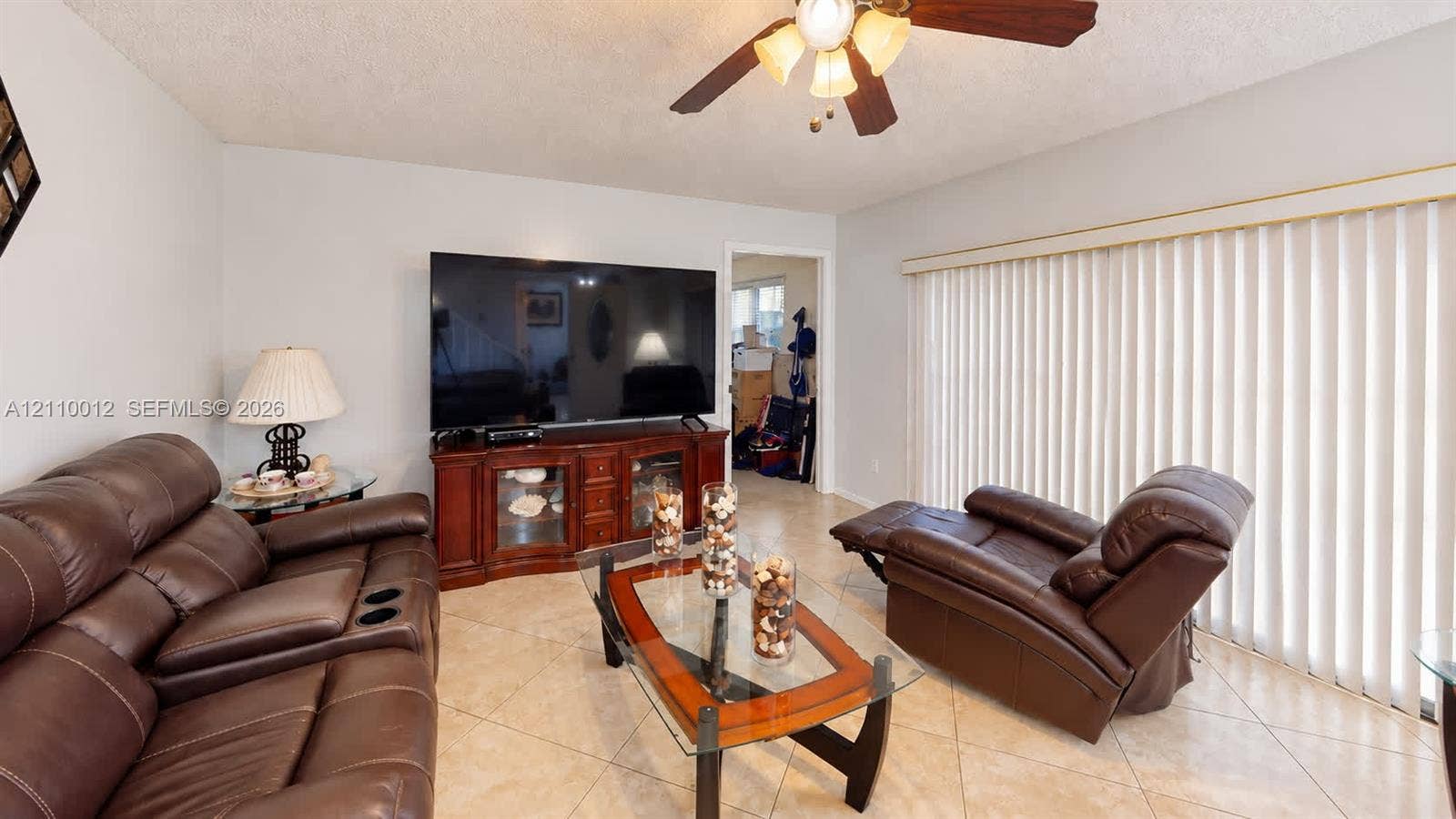 1601 16th Terrace, Palm Beach Gardens, FL 33418 Neutral tile flooring, ceiling fan with light fixture, and vertical window blinds