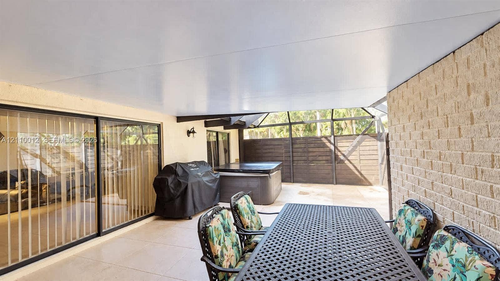 1601 16th Terrace, Palm Beach Gardens, FL 33418 Covered patio featuring concrete tile flooring, a screen-enclosed area, and masonry exterior wall