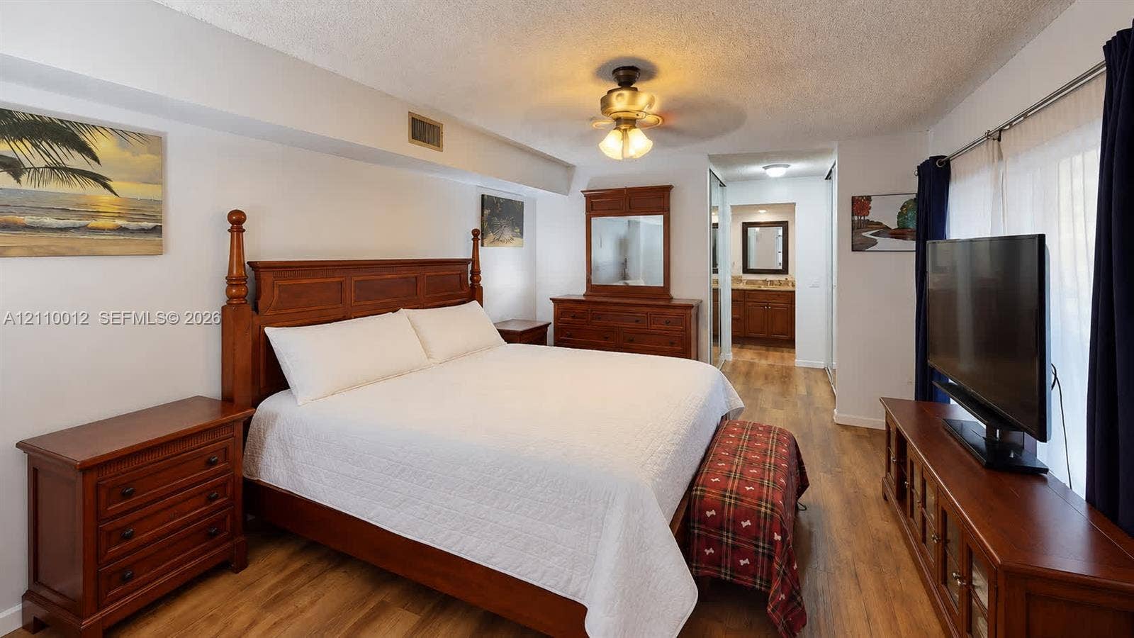 1601 16th Terrace, Palm Beach Gardens, FL 33418 Wood-finish flooring, textured ceiling, and a central ceiling fan with multi-light fixture