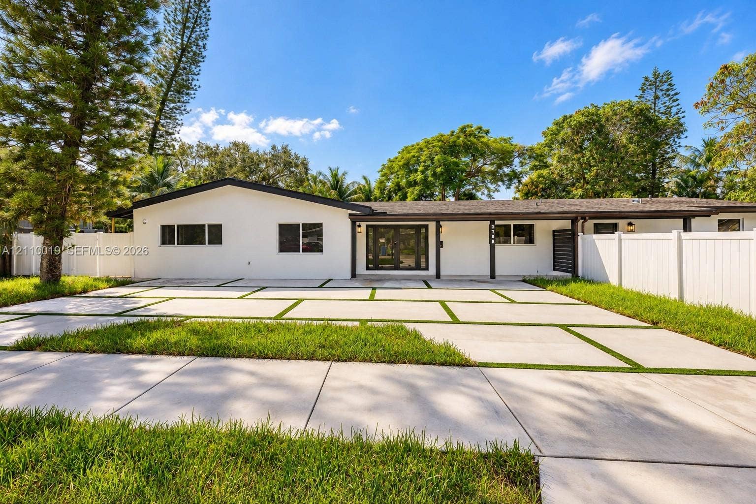 1708 SW 11th Street, Fort Lauderdale, Fort Lauderdale, FL 33312 Single-story exterior featuring white stucco siding, a concrete paver driveway with turf accents, a covered porch, and privacy fencing