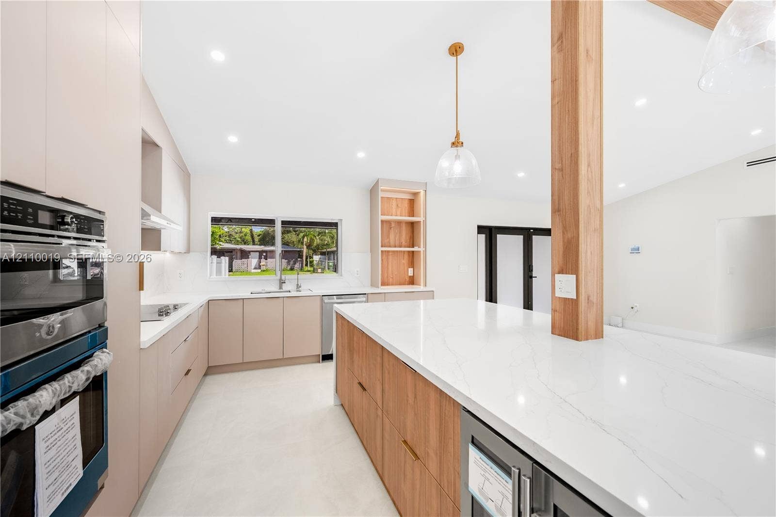 1708 SW 11th Street, Fort Lauderdale, Fort Lauderdale, FL 33312 Kitchen featuring flat-panel cabinetry, a spacious stone-surfaced island, integrated stainless steel appliances, a structural wood pillar, and recessed lighting