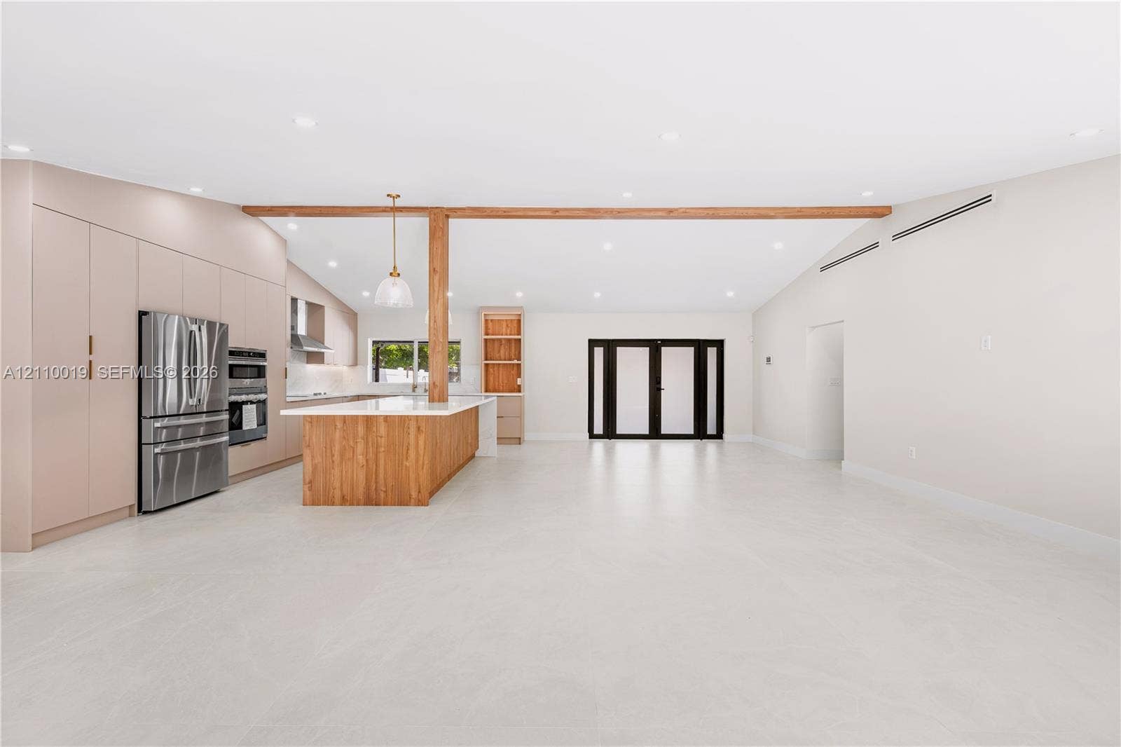 1708 SW 11th Street, Fort Lauderdale, Fort Lauderdale, FL 33312 Open-concept kitchen featuring full-height flat-panel cabinetry, a wood-finish island with integrated storage, stainless steel appliances, a structural wood beam, and light-toned tile flooring