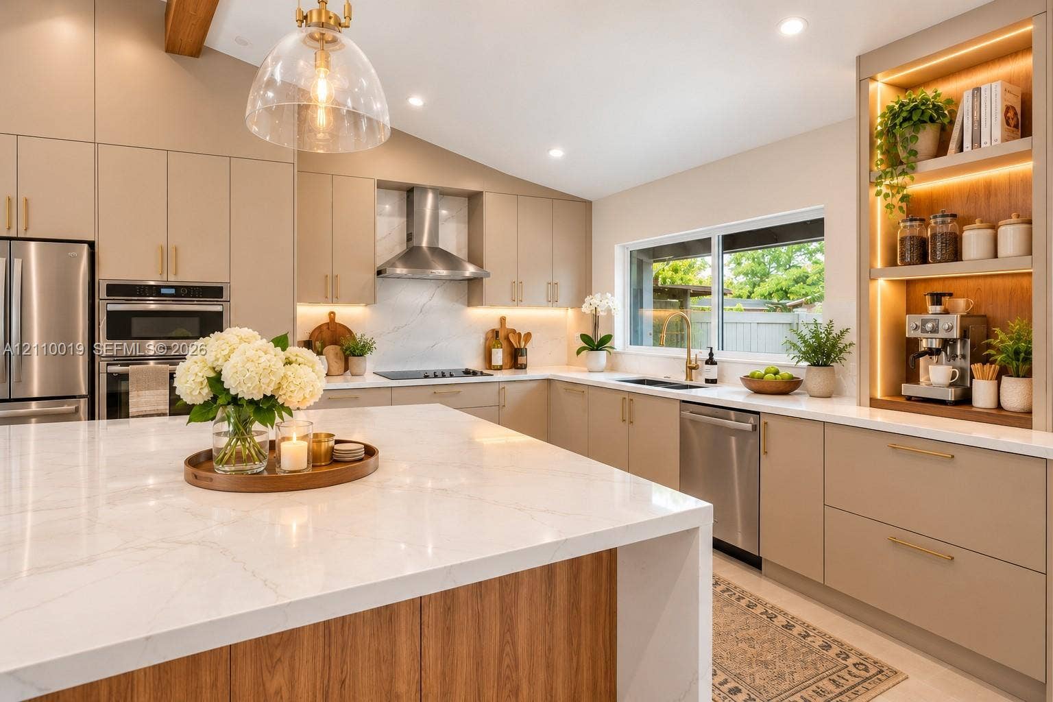 1708 SW 11th Street, Fort Lauderdale, Fort Lauderdale, FL 33312 Kitchen featuring an oversized waterfall island with stone countertop, flat-panel cabinetry, stainless steel appliances, a built-in illuminated display nook, and vaulted ceiling